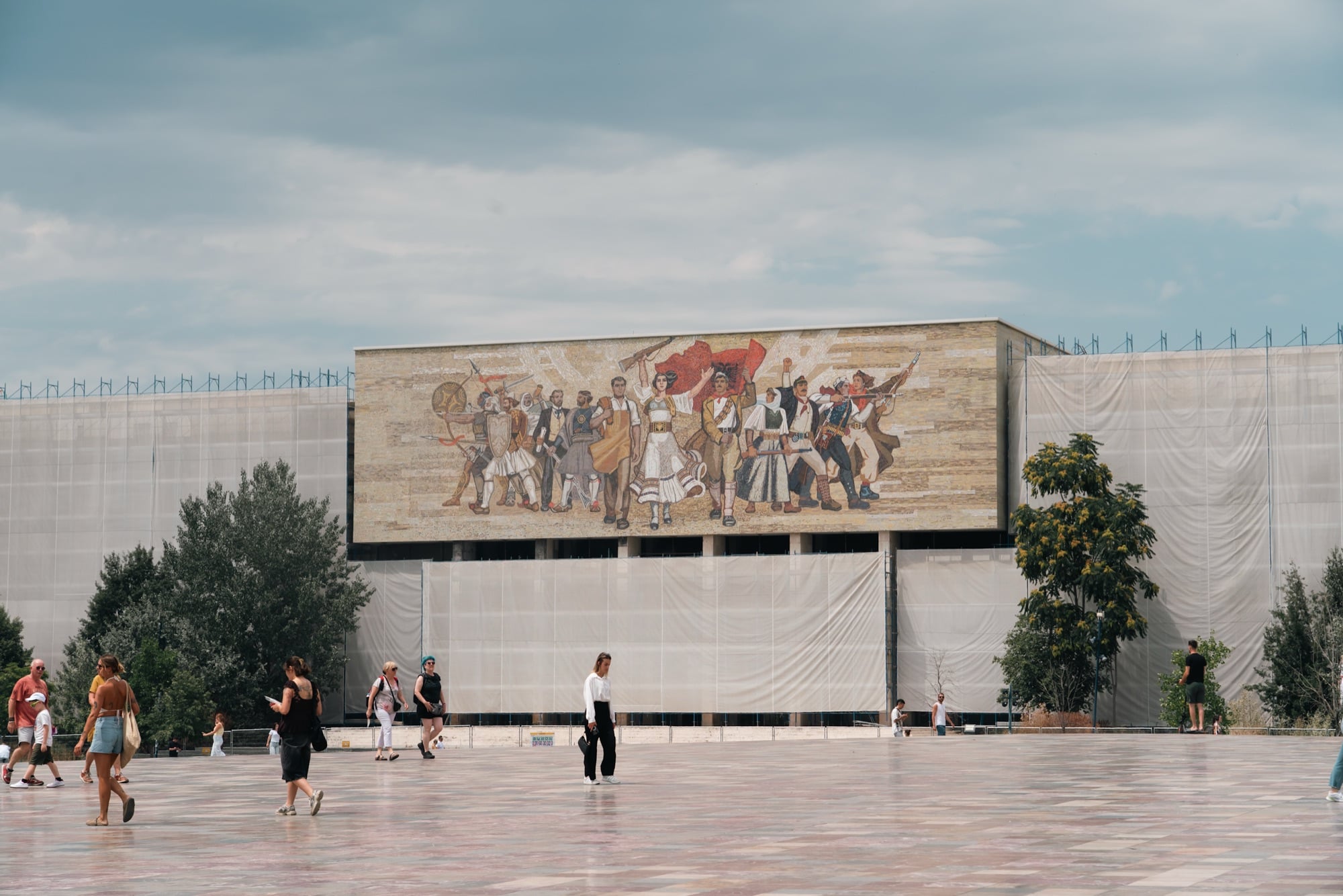 The 'Albanians' mosaic mural on the National History Museum overlooking Skanderbeg Square, the wings under scaffolding
