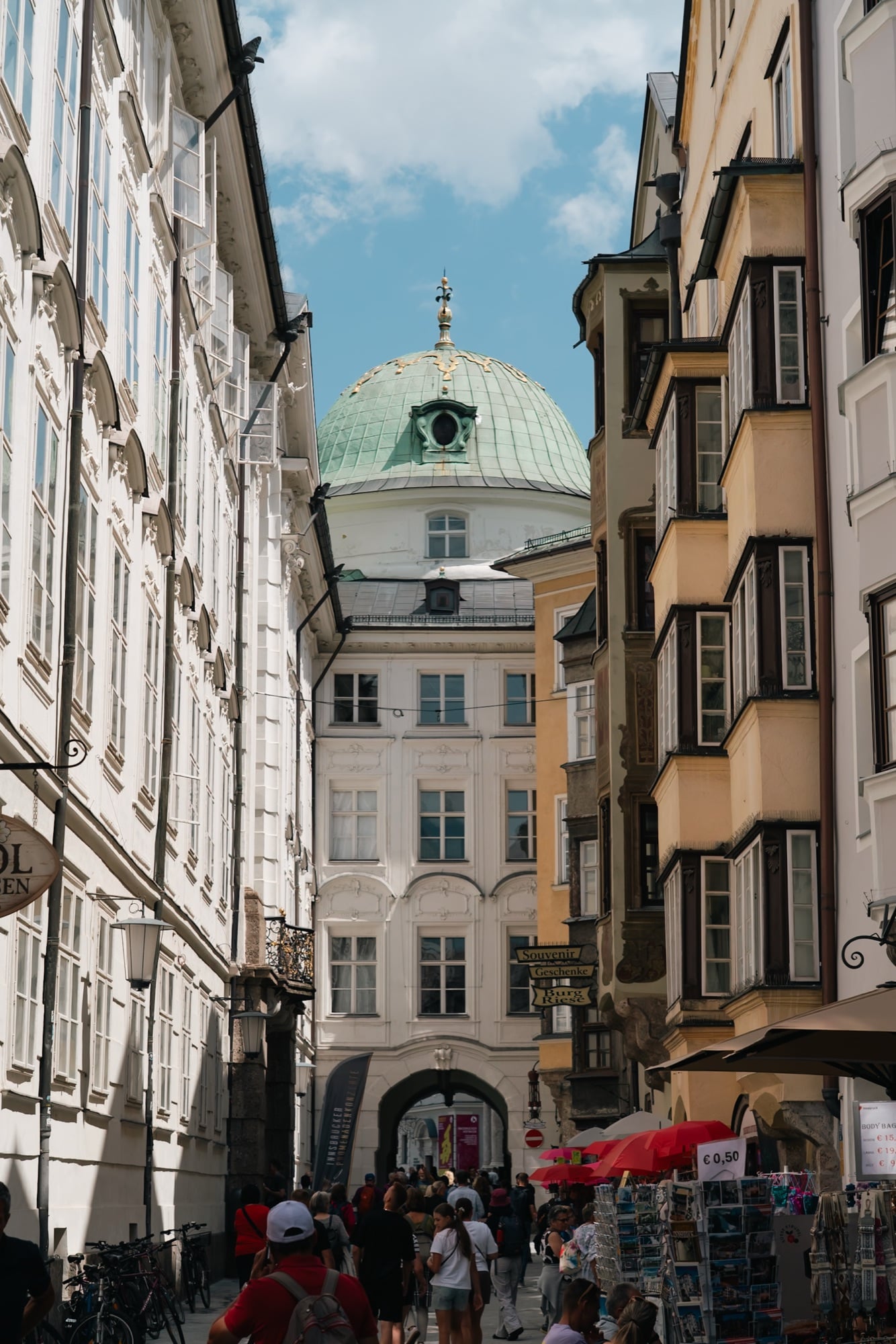 An old-town alley with a green church dome beyond, Innsbruck