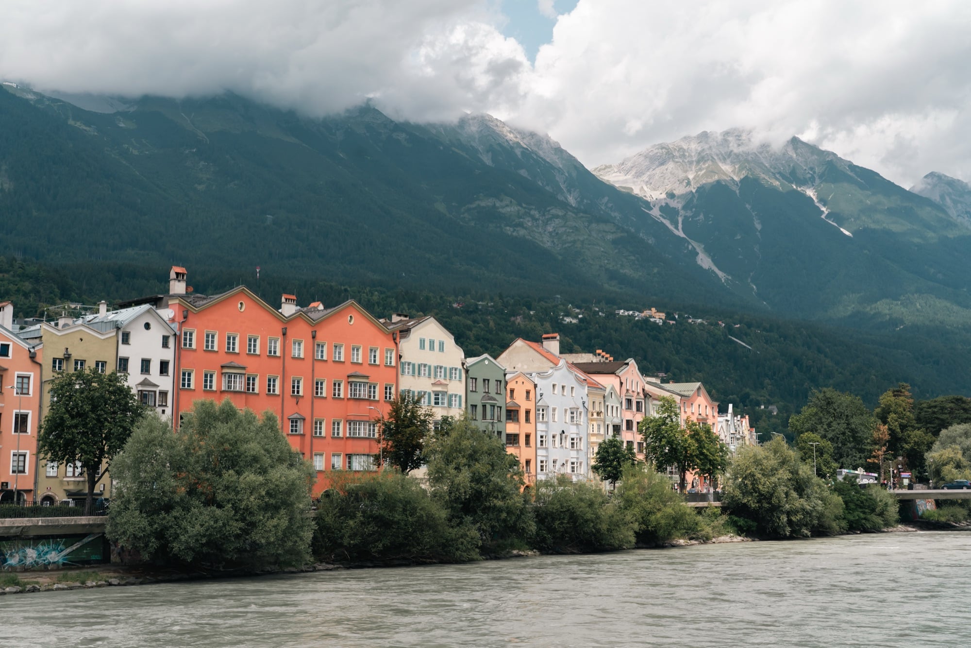 Colourful houses lining the Inn river beneath the mountains, Innsbruck