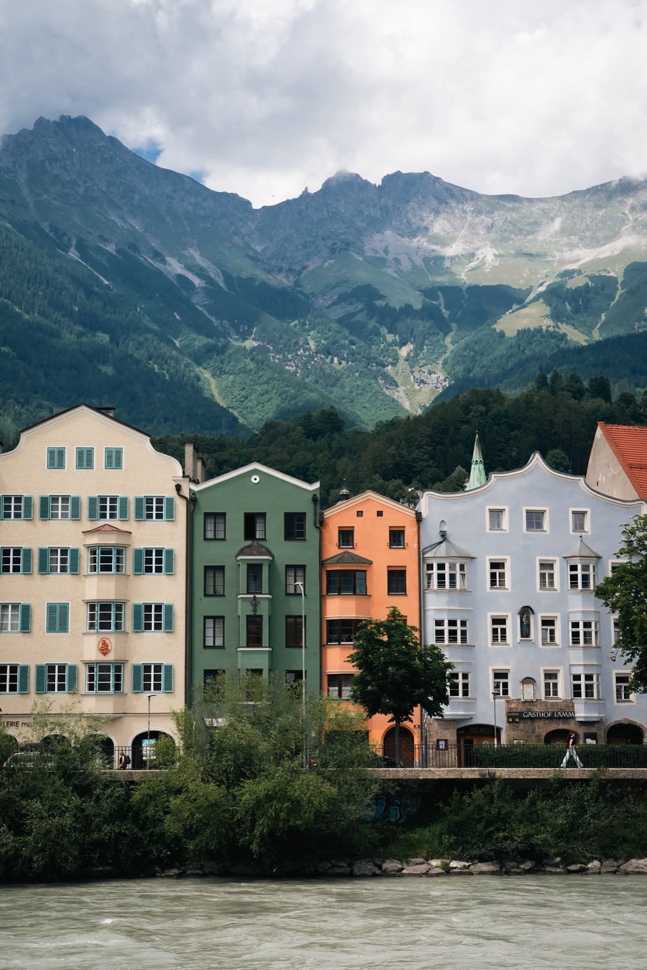 The pastel row houses of the Mariahilf quarter rising above the Inn river, the Nordkette behind, Innsbruck