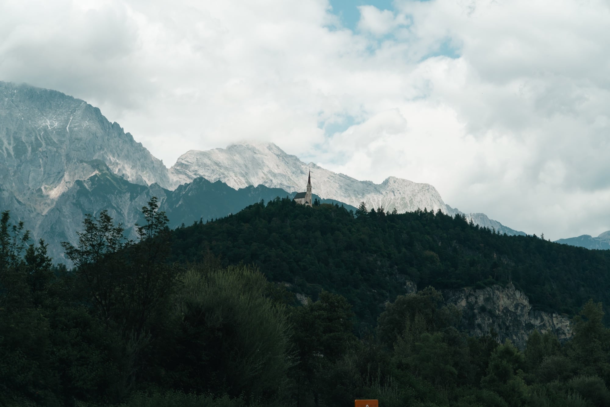 Forested ridges and a cloud-draped peak in Tyrol