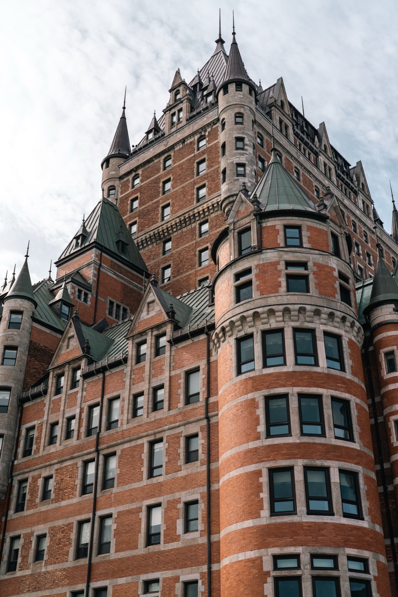 The round brick tower and green turrets of the Château Frontenac seen from below