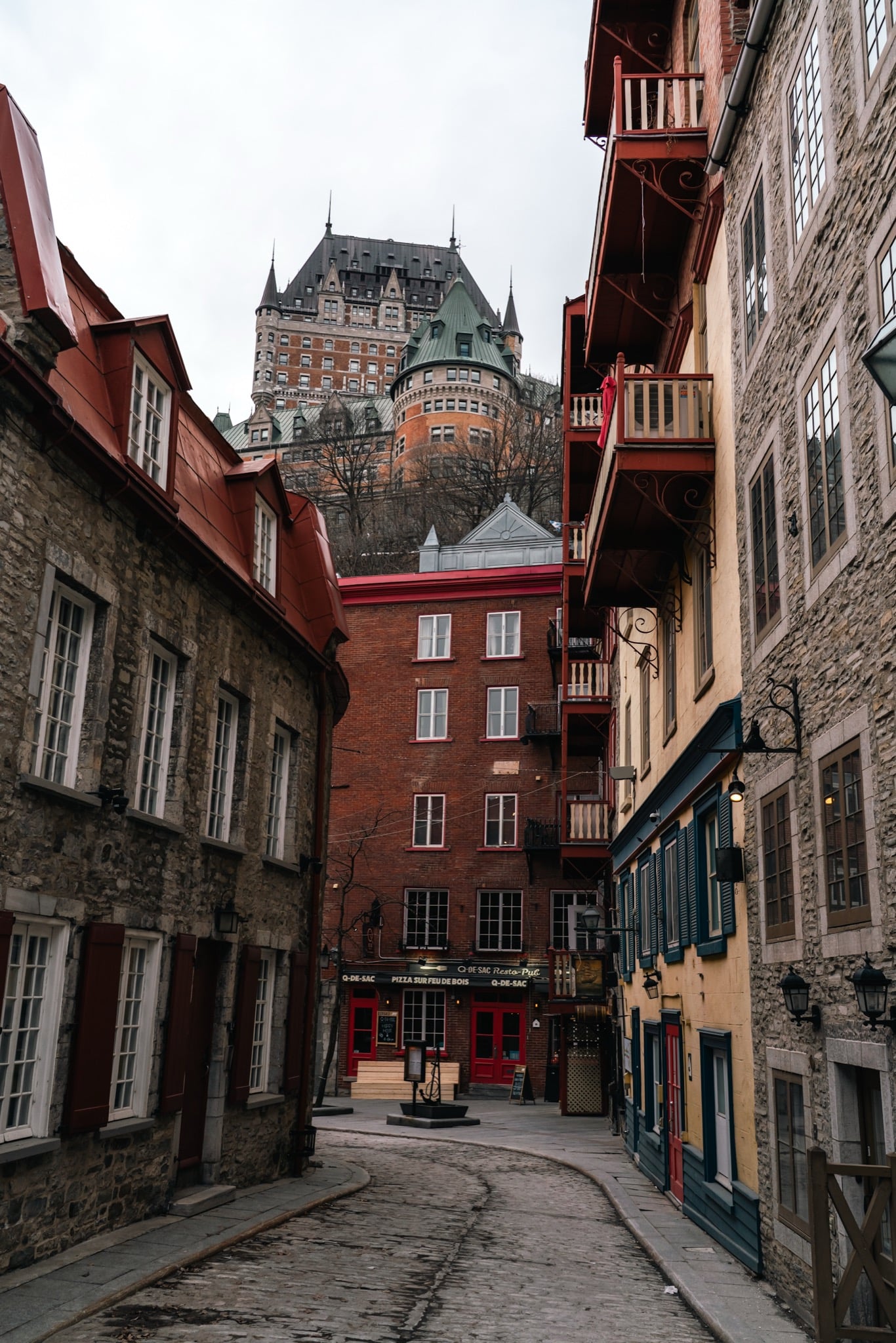 The Château Frontenac rising over a red-brick lane