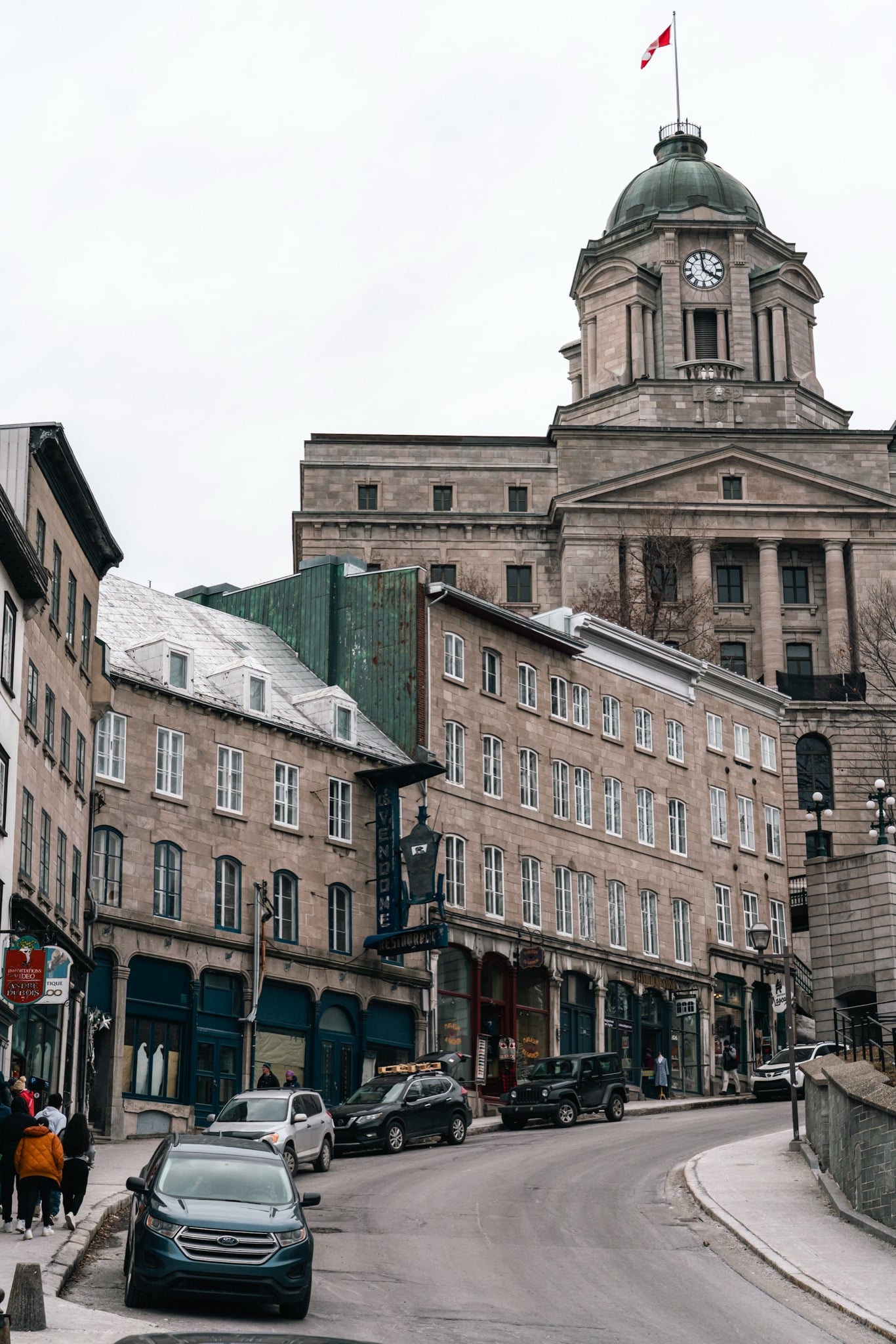 A winter street ending at a domed building in Old Quebec