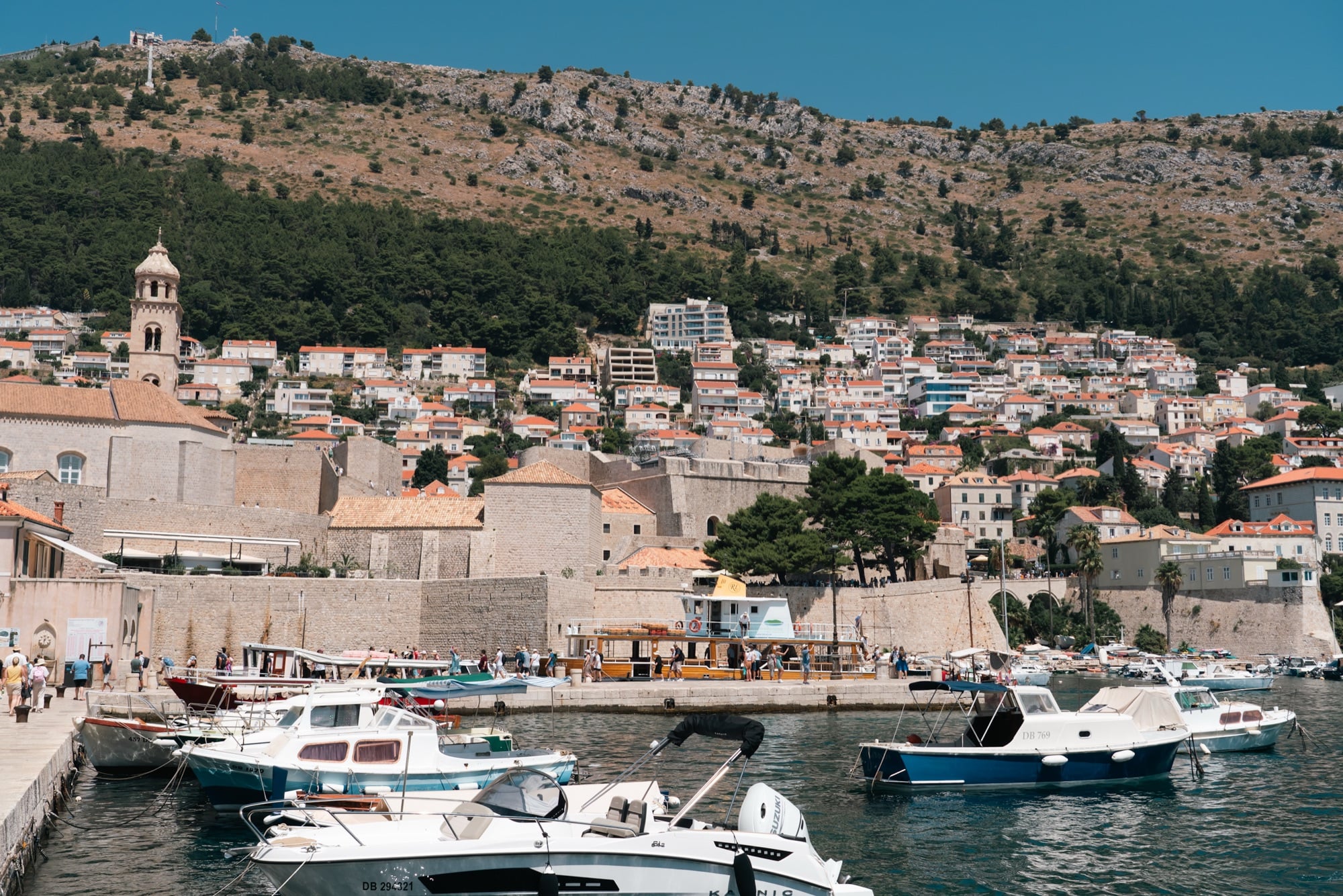 Fishing boats in the harbour before the Old Town rooftops and clock tower, Dubrovnik