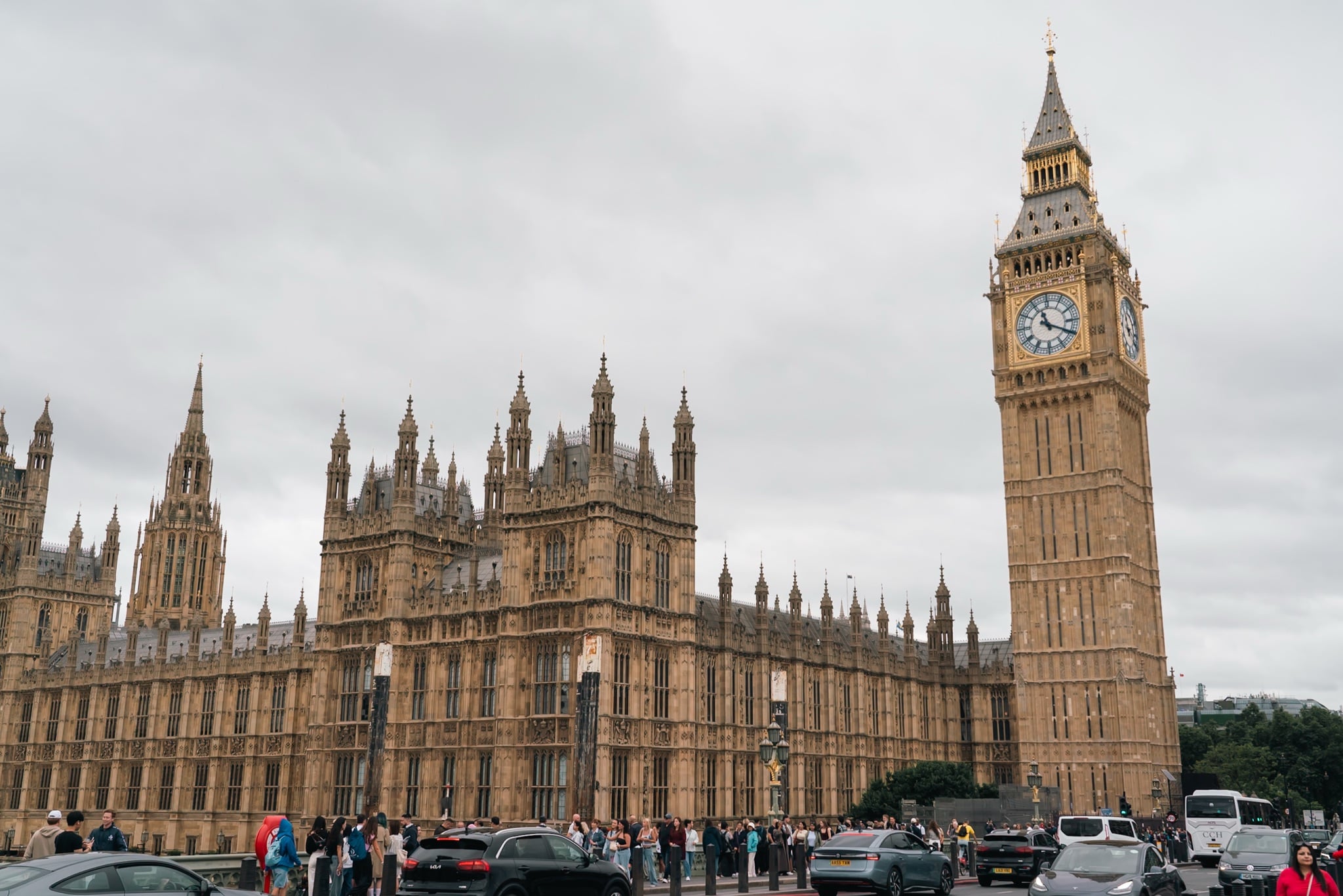 Big Ben and the Palace of Westminster above the crowds and traffic of Parliament Square