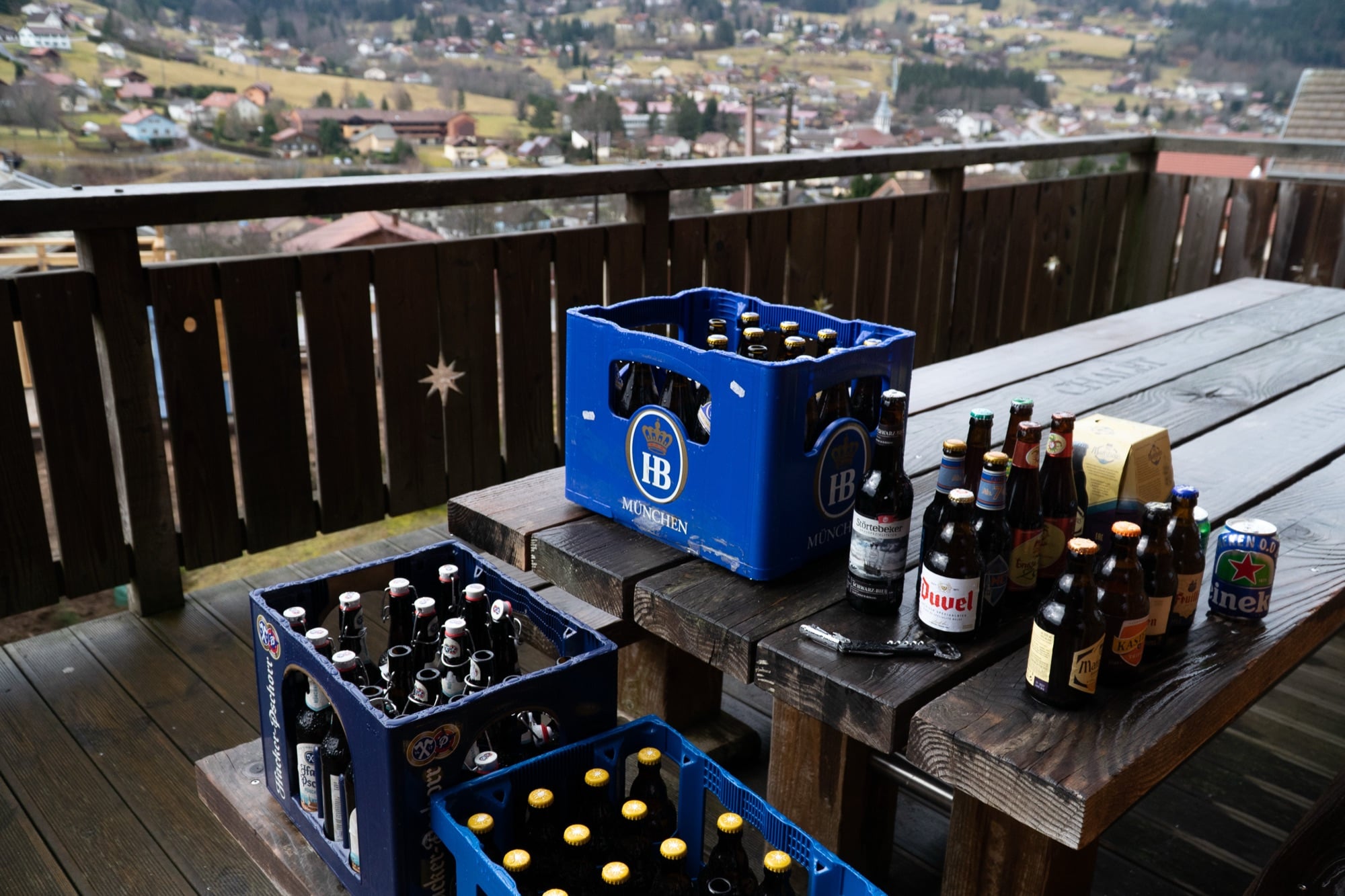 Crates of beer bottles on a wooden chalet terrace overlooking the Gérardmer valley
