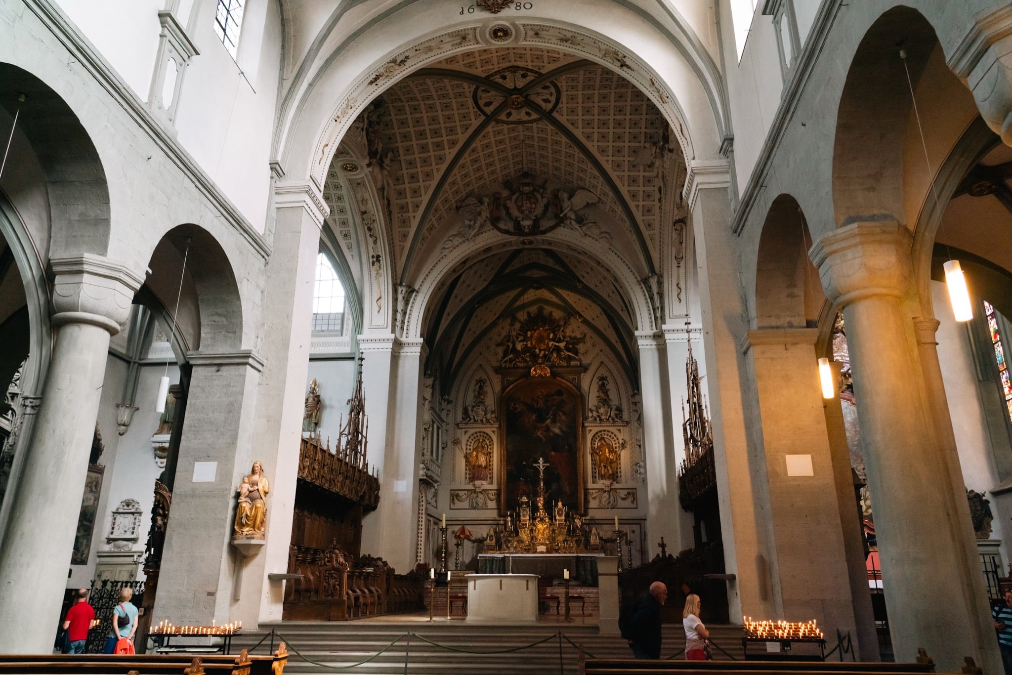 The long flank of the Konstanz Minster with its green spire and a Marian column out front