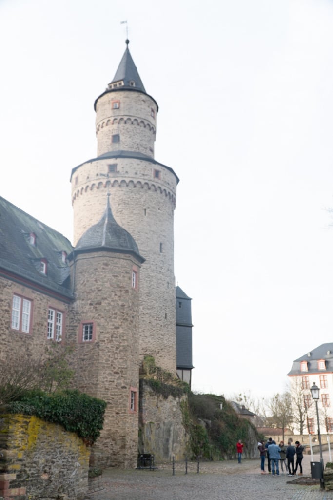 A round medieval tower crowned with a pointed slate cap above the old town, Limburg