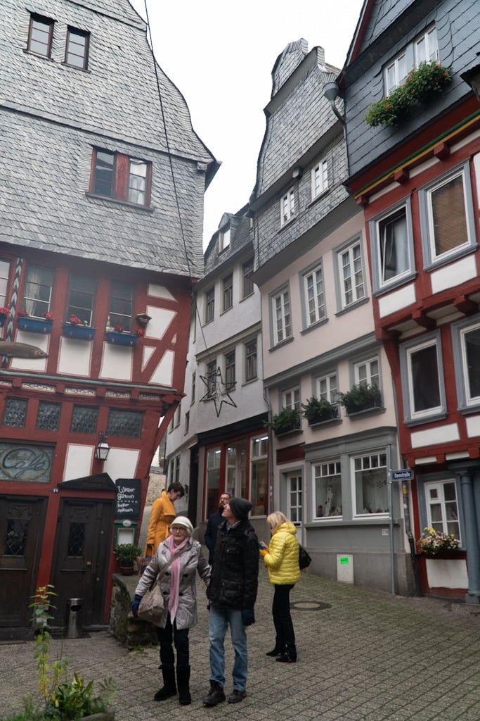 A tall half-timbered house with a decorative clock on a Limburg old-town corner