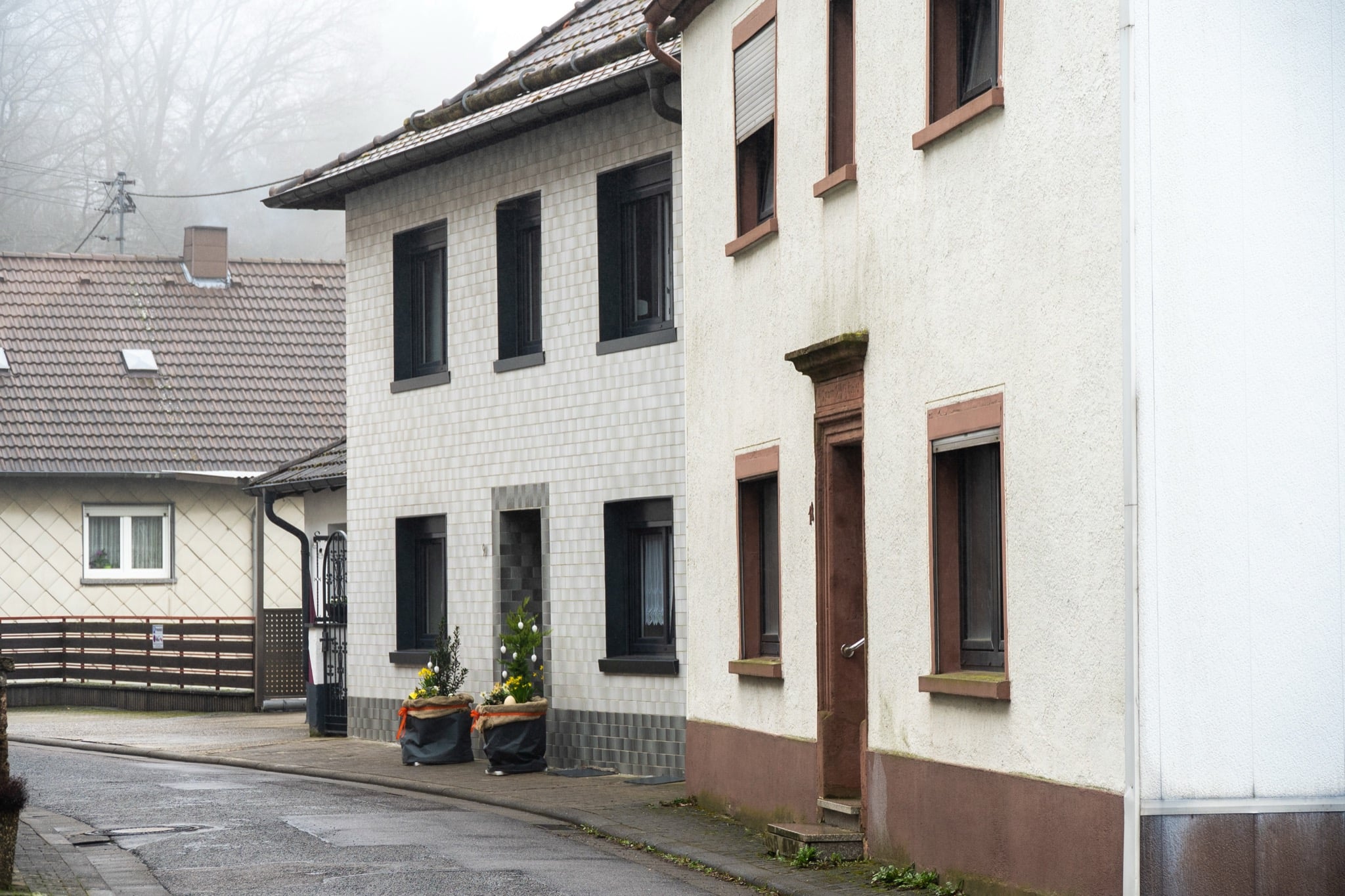 Tidy village houses along a quiet, misty street in Ramstein