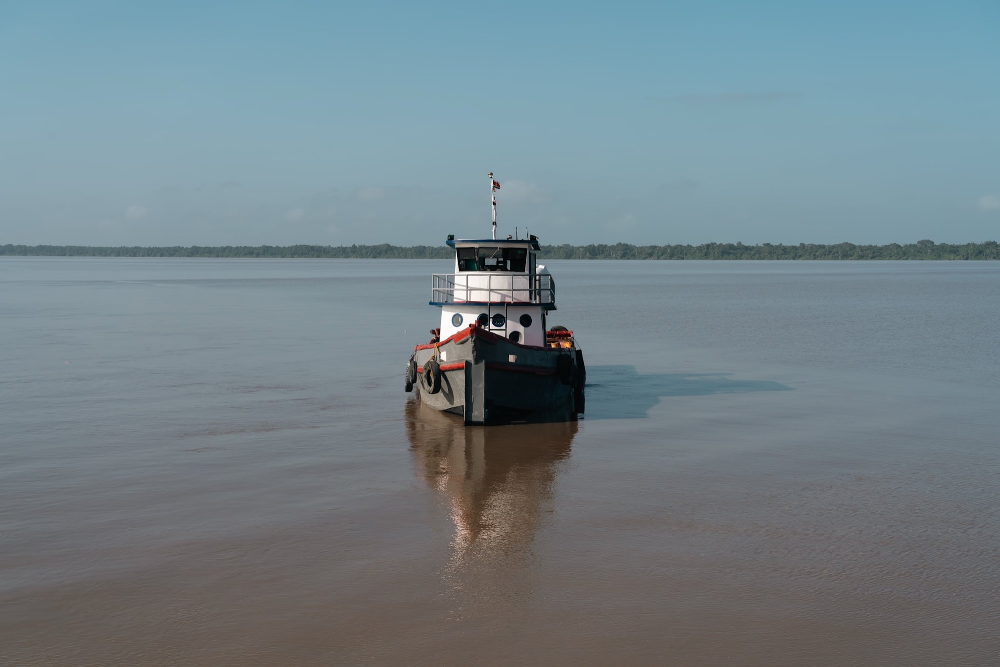 A boat crossing the wide brown Courantyne River on Guyana's eastern border