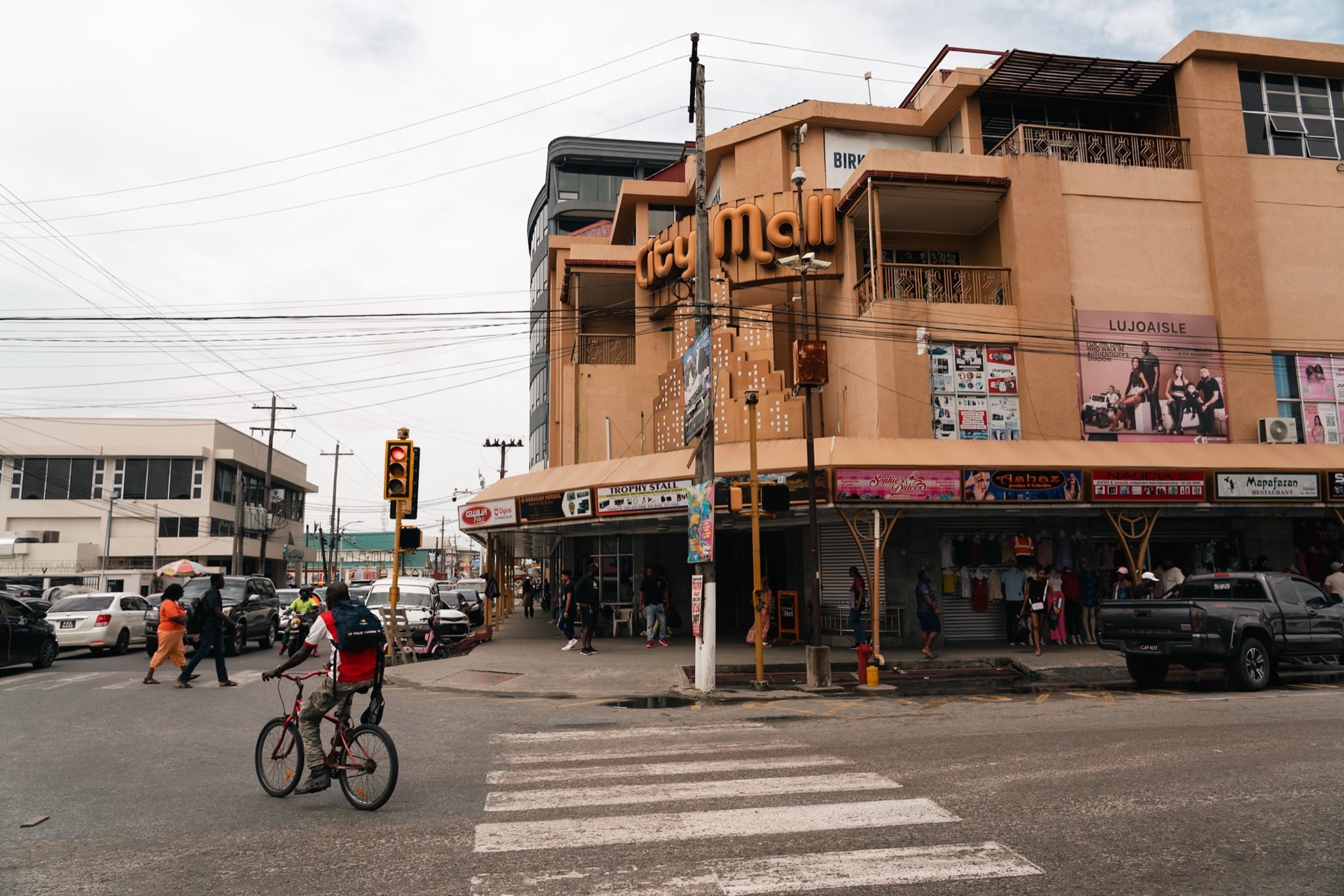 A cyclist crossing at a shopfront corner in Georgetown