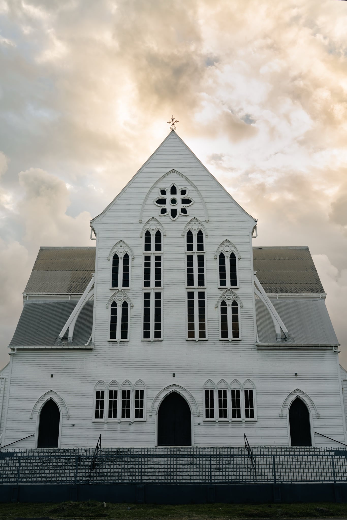 The white timber facade of St. George's Cathedral against a stormy sky