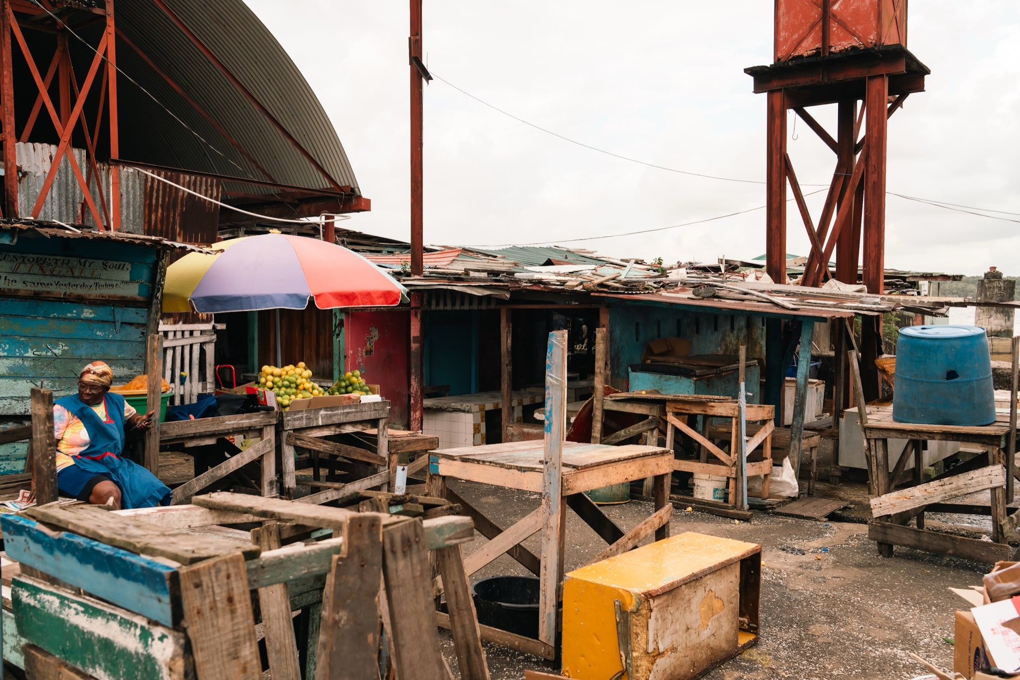 Weathered wooden stalls and a water tower behind Stabroek Market