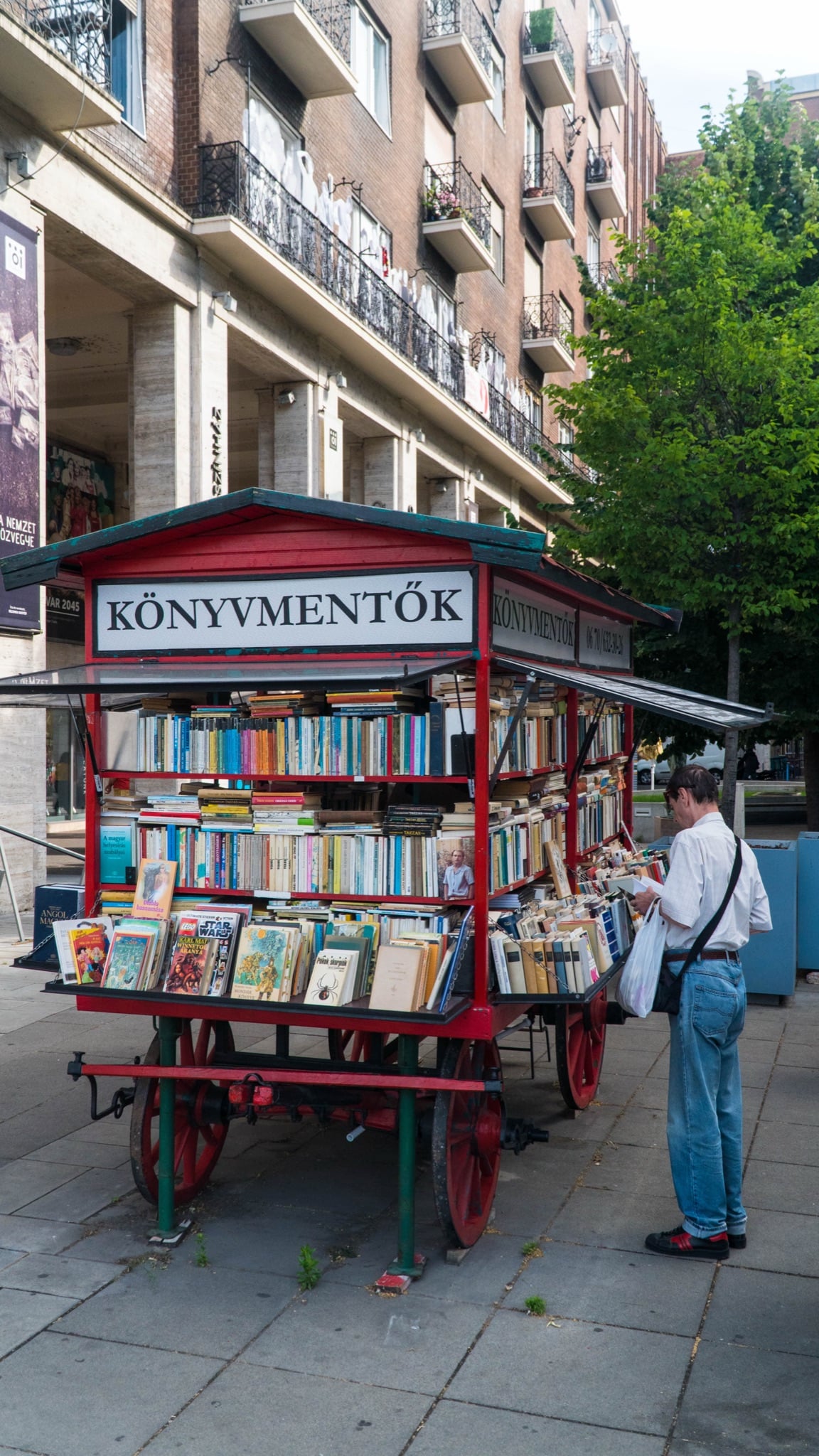 A vintage red book cart, Könyvmentők, stacked with secondhand titles