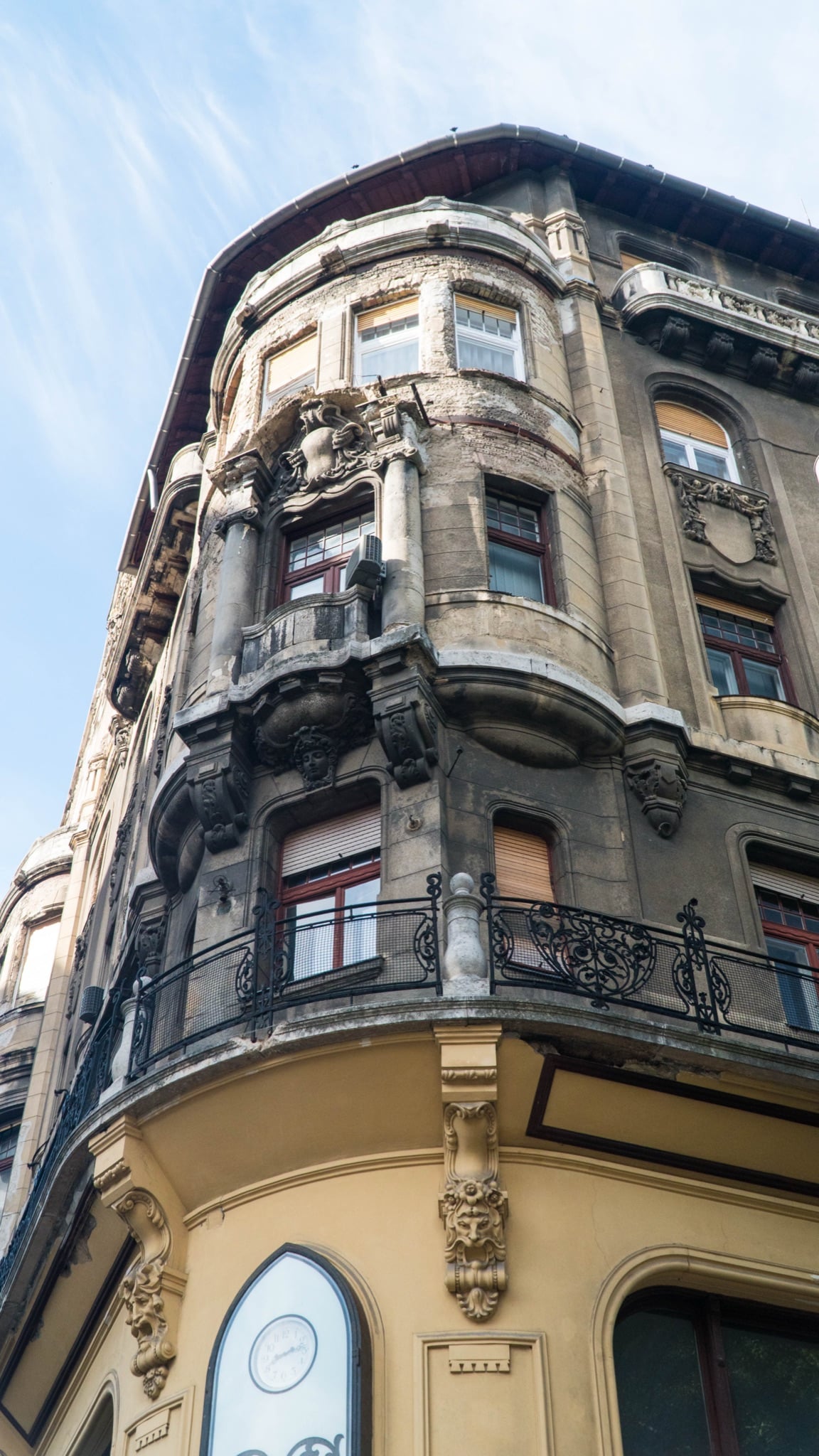 An ornate corner apartment house with a rounded bay and wrought-iron balcony