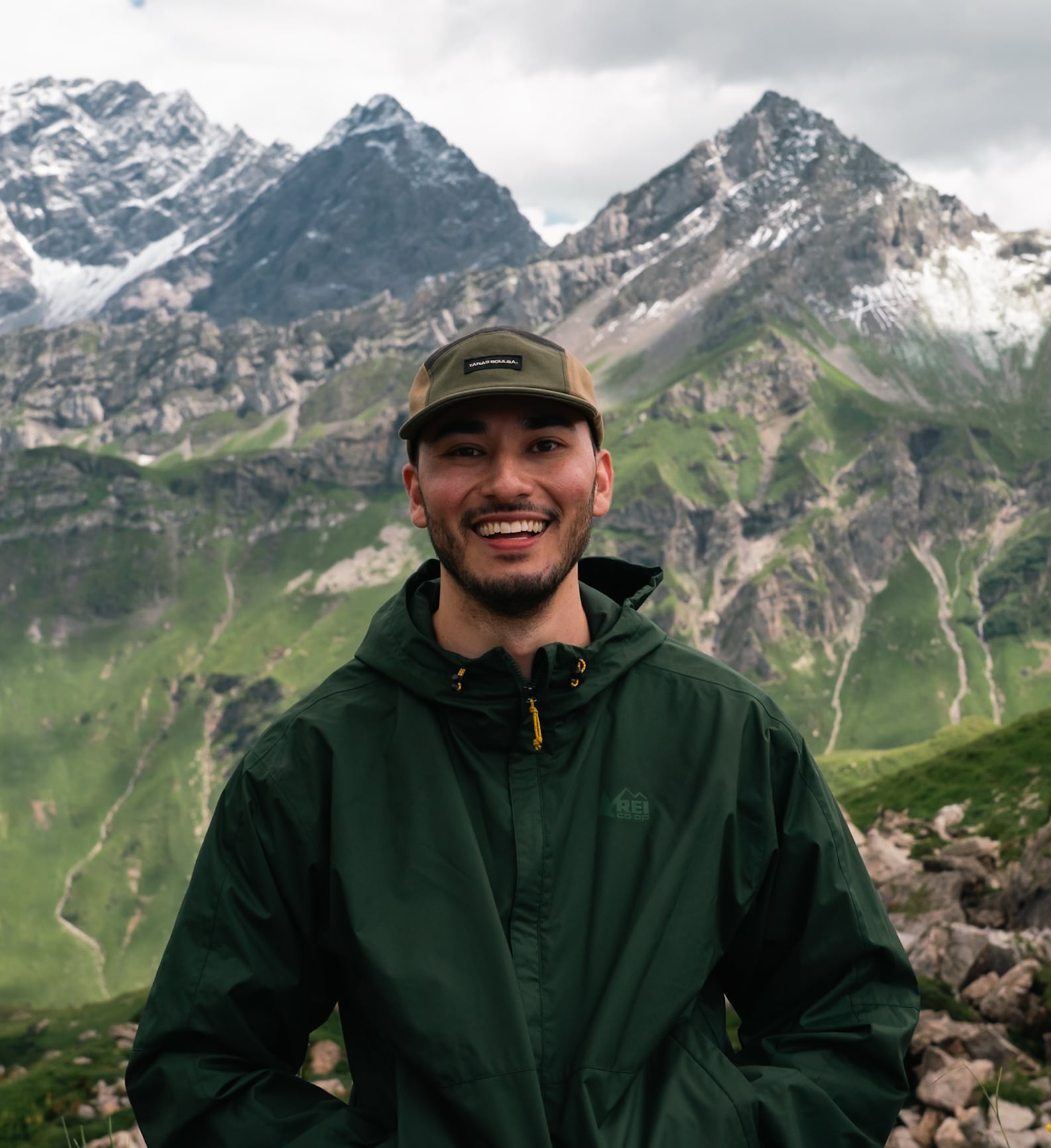 Kendrick smiling in front of an alpine ridge