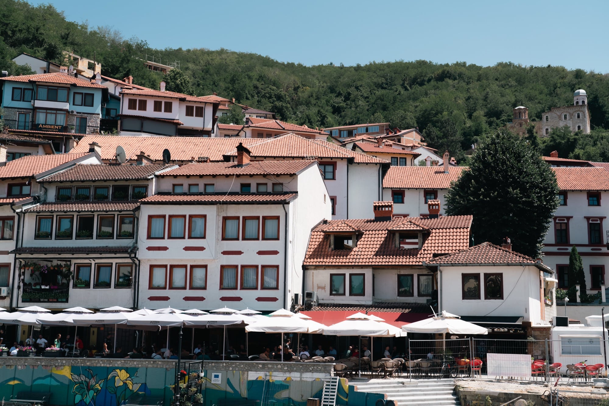 Red-tiled Ottoman houses stacked up the green hillside above Prizren's riverside cafés, a ruined church on the slope beyond
