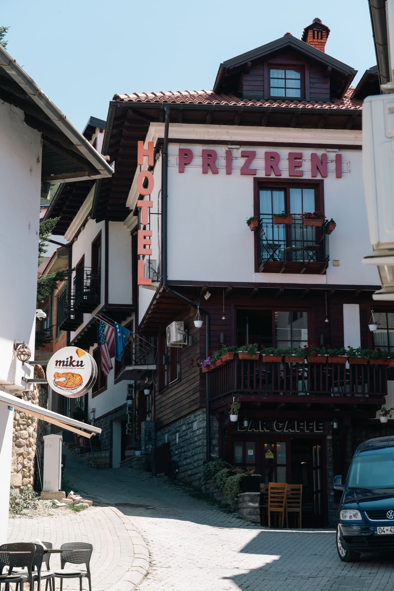 The timber-framed Hotel Prizreni with US, Kosovo and EU flags on a narrow cobbled lane in Prizren's old quarter