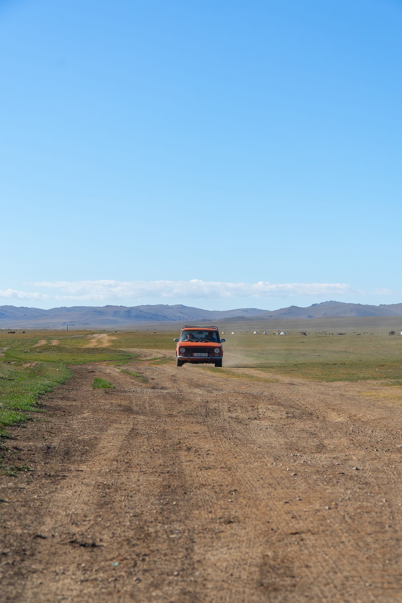 A car parked on the grassland during the drive up to Song-Kul