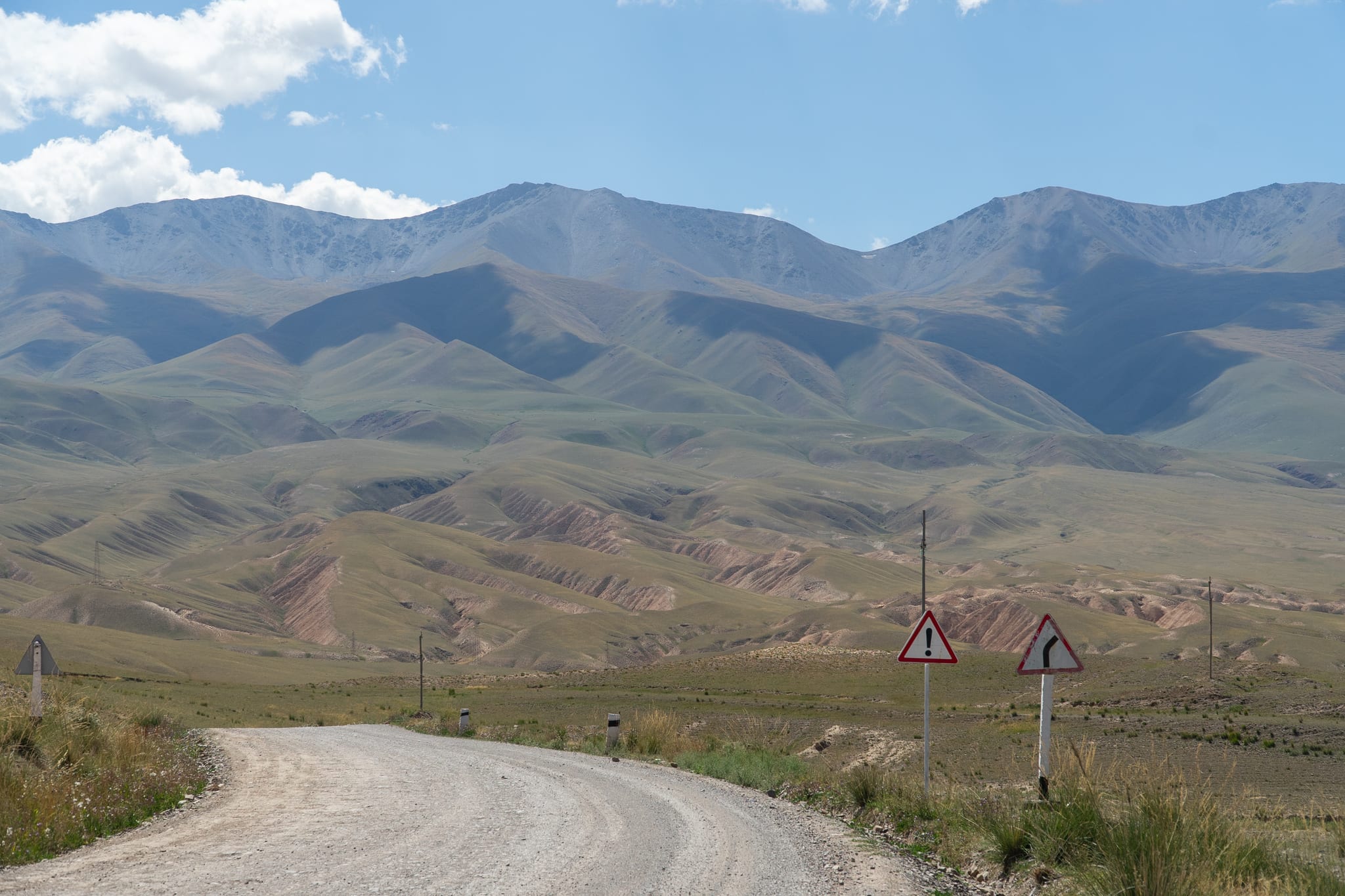 A dirt track crossing the open plateau toward Song-Kul