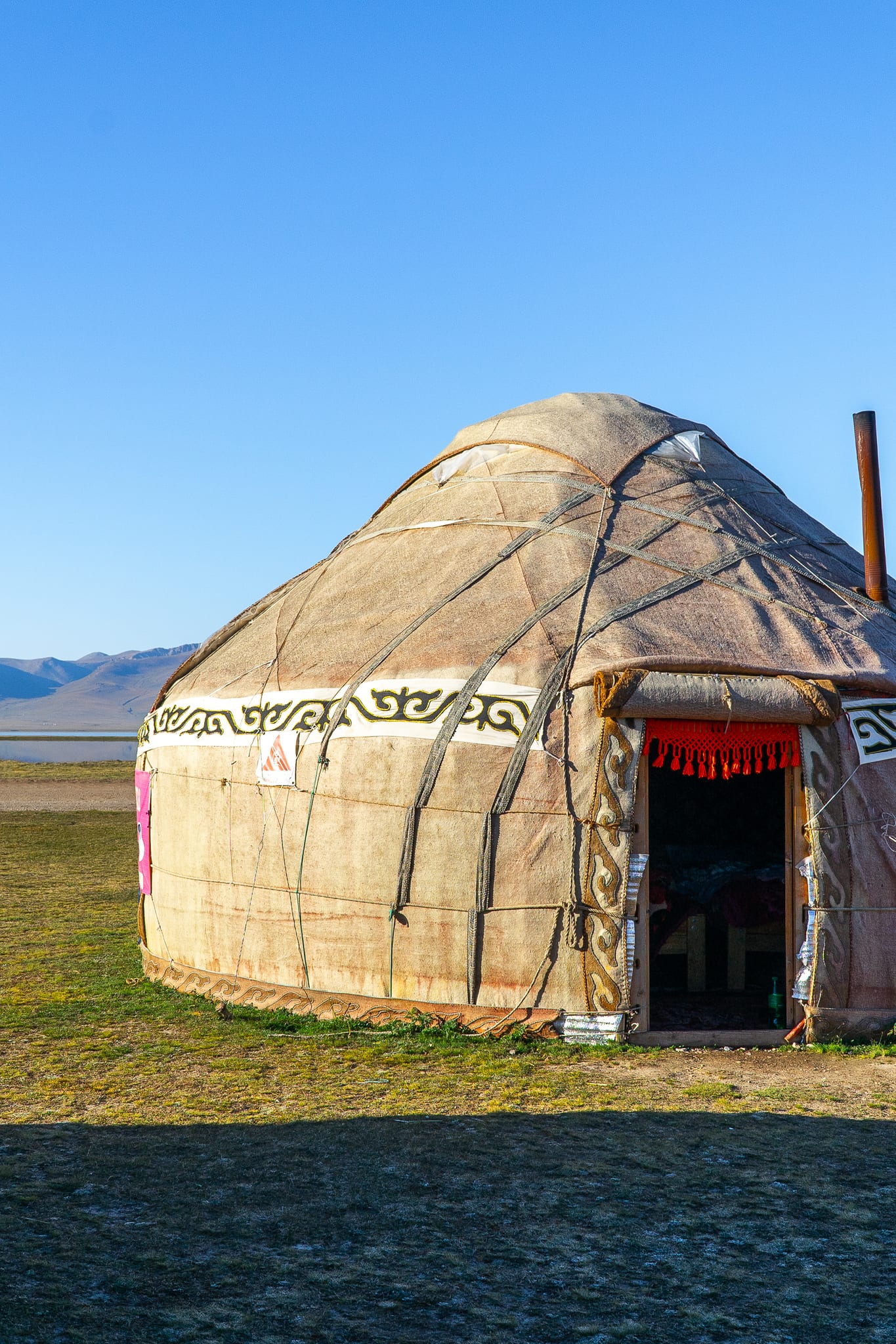 A single yurt standing on the open grassland at Song-Kul
