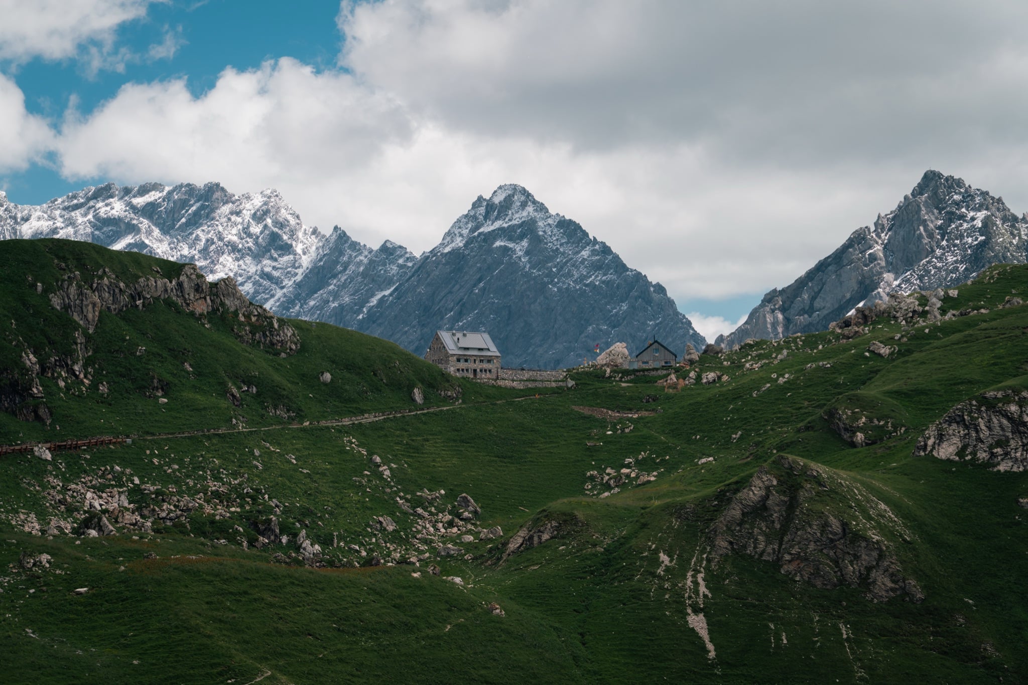 Stone hut on a Liechtenstein ridge under moving cloud