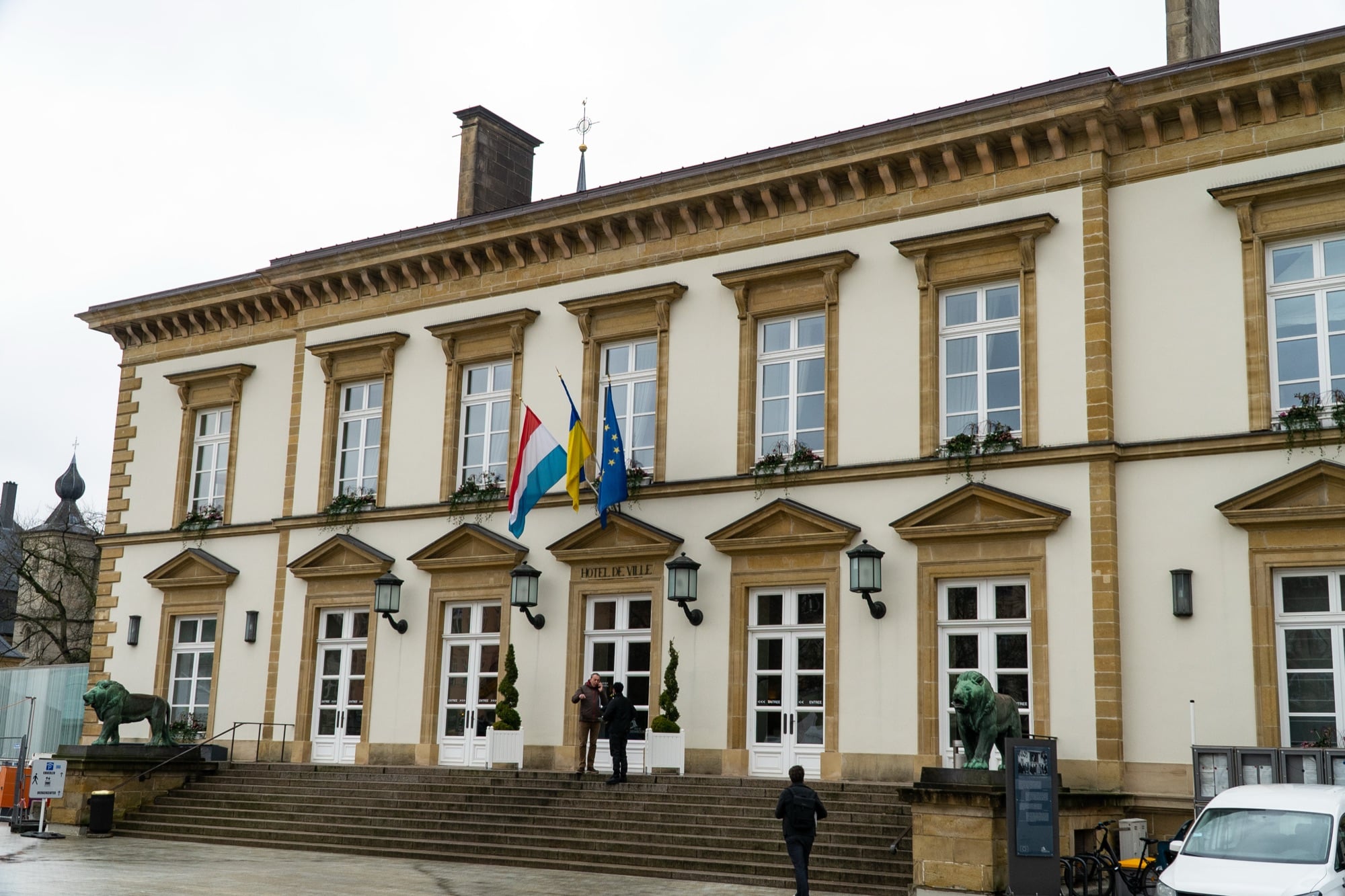 The Hôtel de Ville flanked by its bronze lions, with the Luxembourg, Ukrainian and EU flags out front