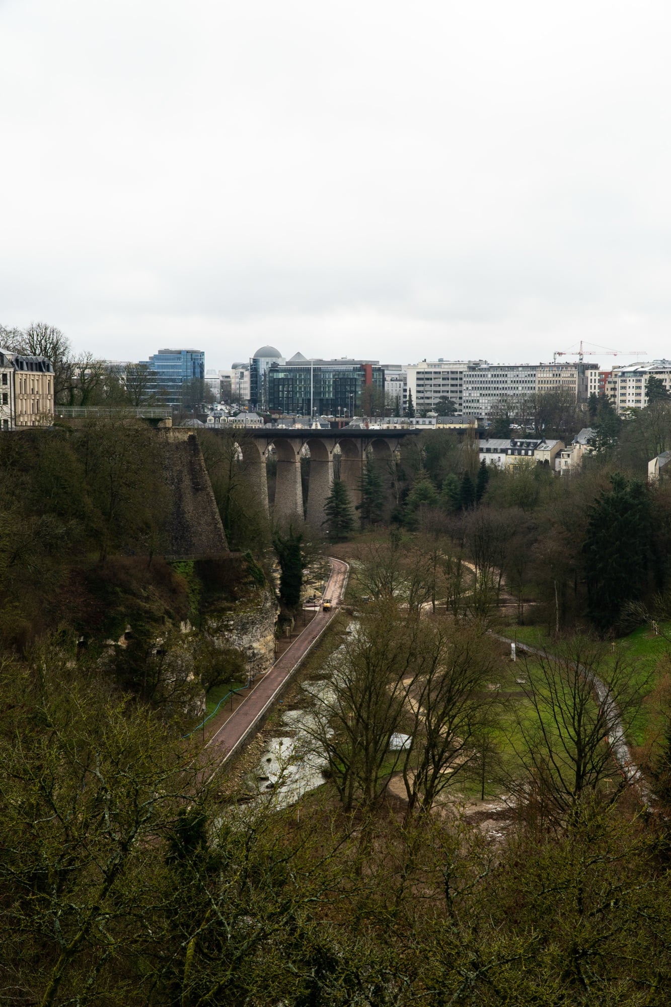 A stone viaduct spanning the green Alzette valley below the modern city, Luxembourg City