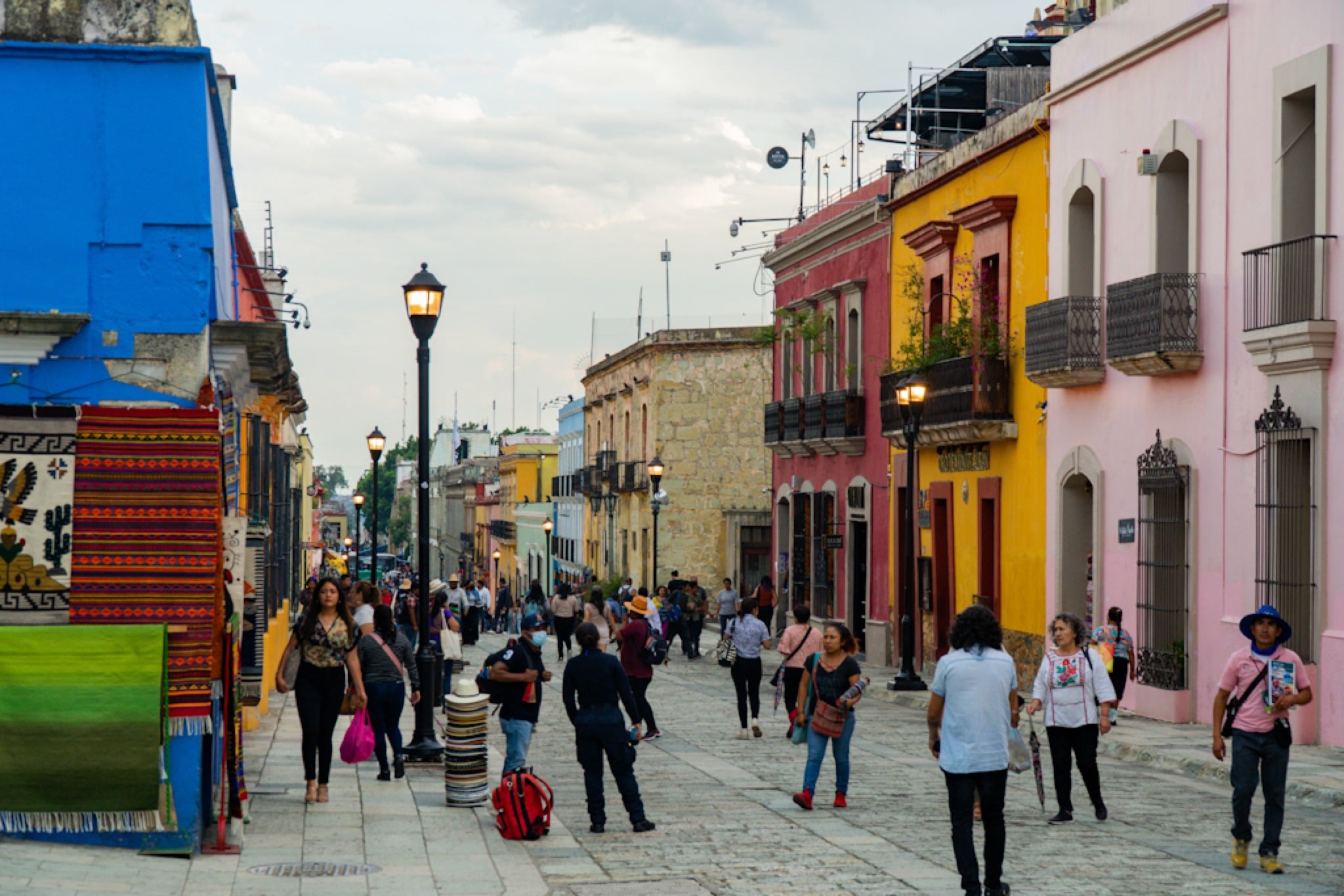 Strollers along a street of brightly painted colonial facades