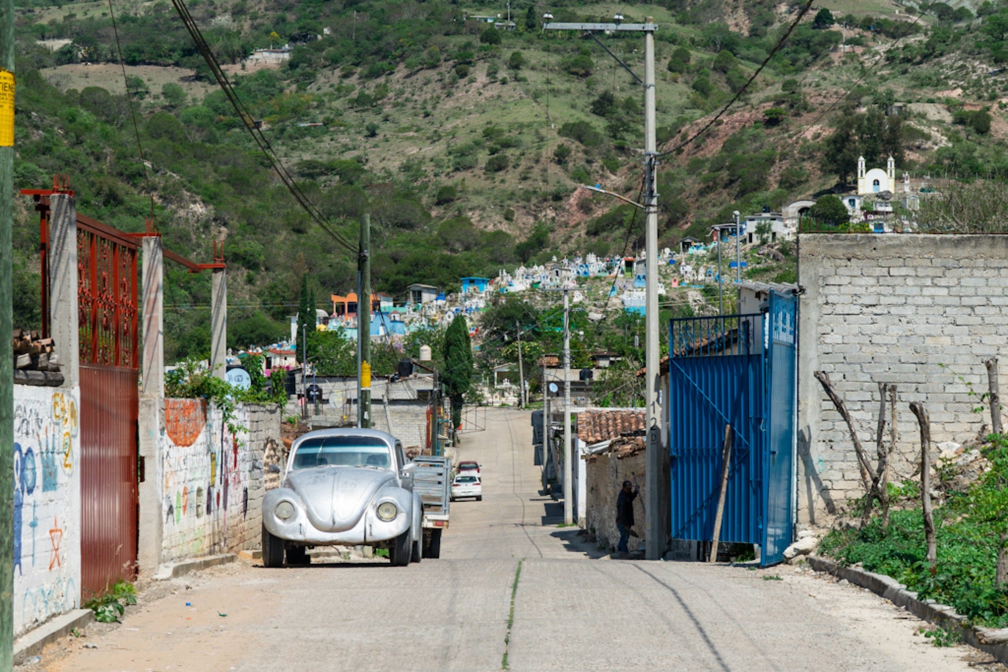 A classic Beetle parked on a sloping village street