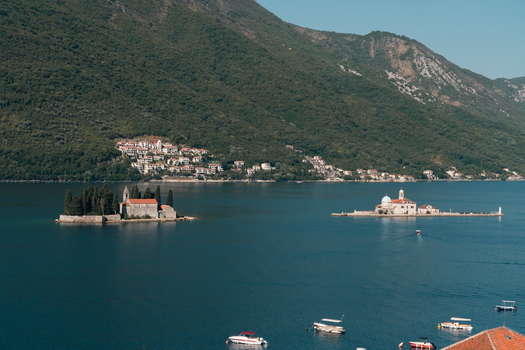 Perast's two islets in the Bay of Kotor — St George with its cypresses and Our Lady of the Rocks with its blue dome — seen from the hillside above