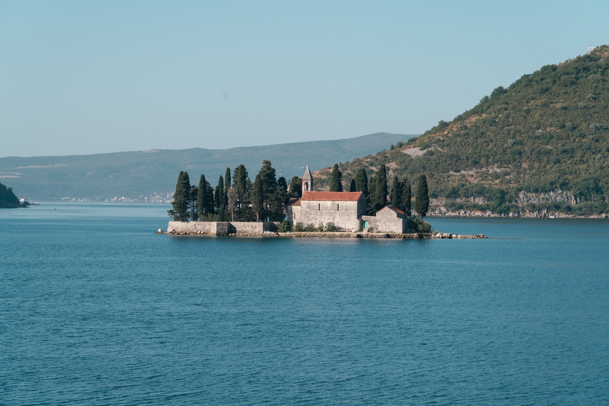 The islet of St George in the Bay of Kotor, its old monastery and dark cypresses ringed by a low stone wall on the still water