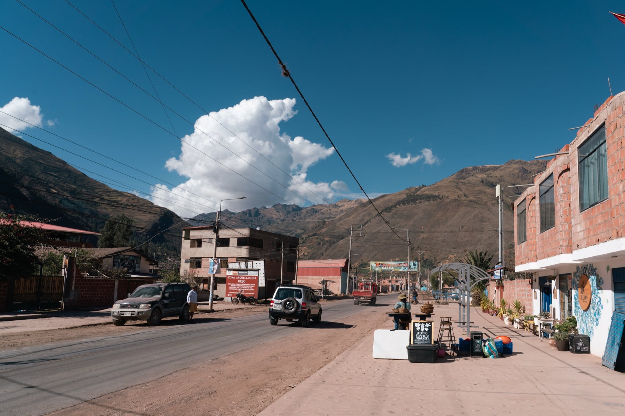 A trailhead town's main road under a wide Andean sky