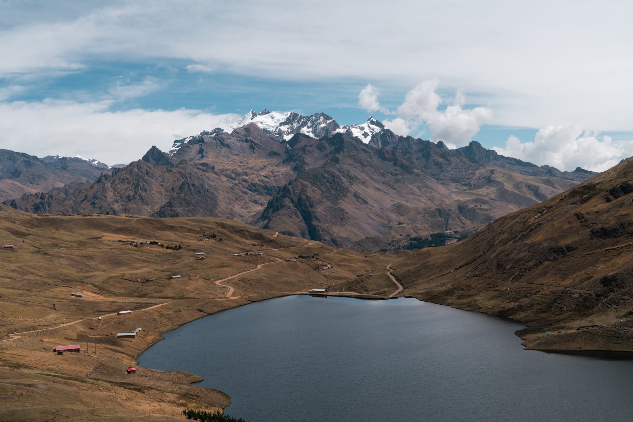 Golden highland grass sloping down to a still mountain lake