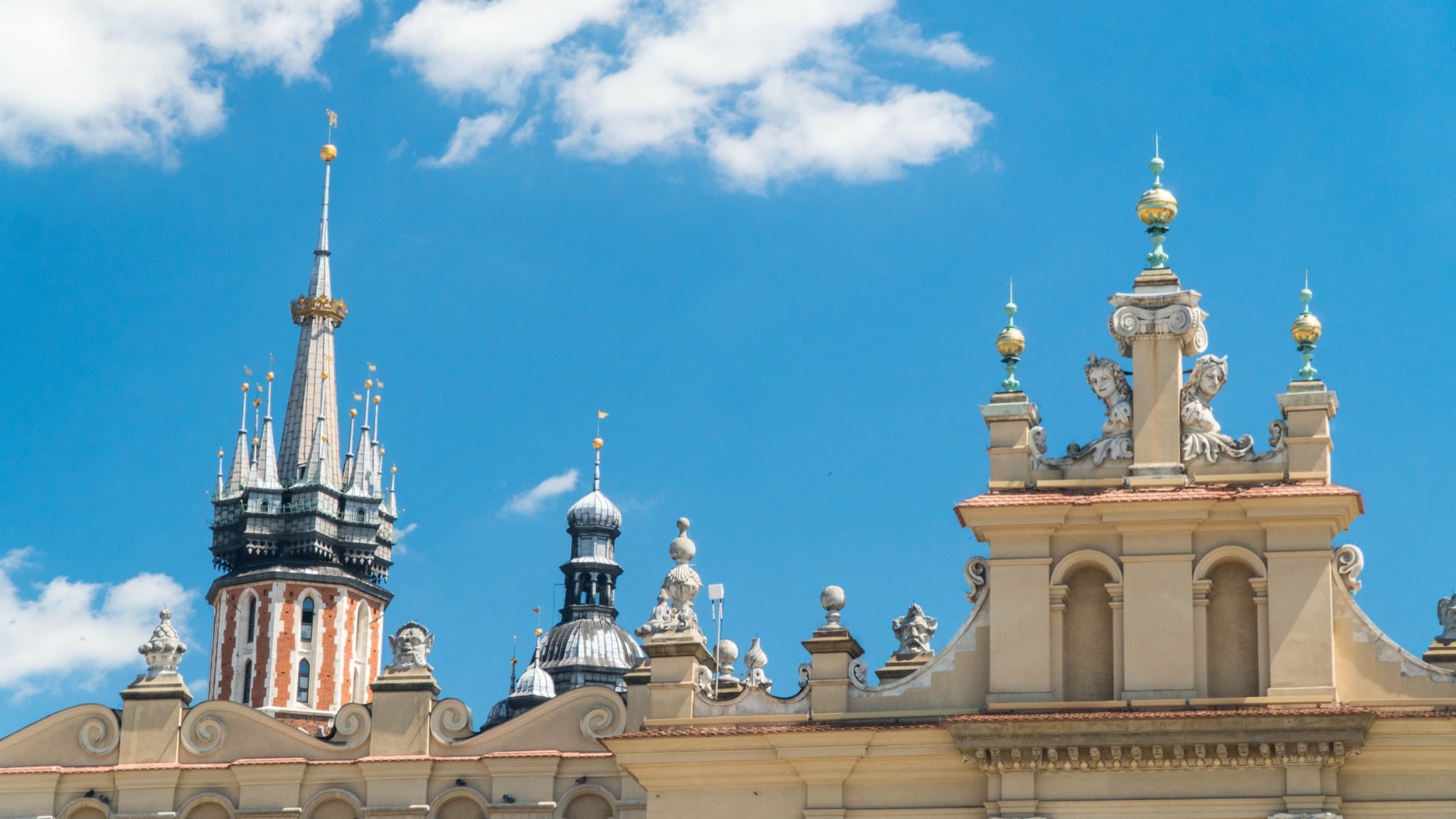 Rooftops of Kraków's Main Square with St. Mary's spire and the ornate attic of the Cloth Hall