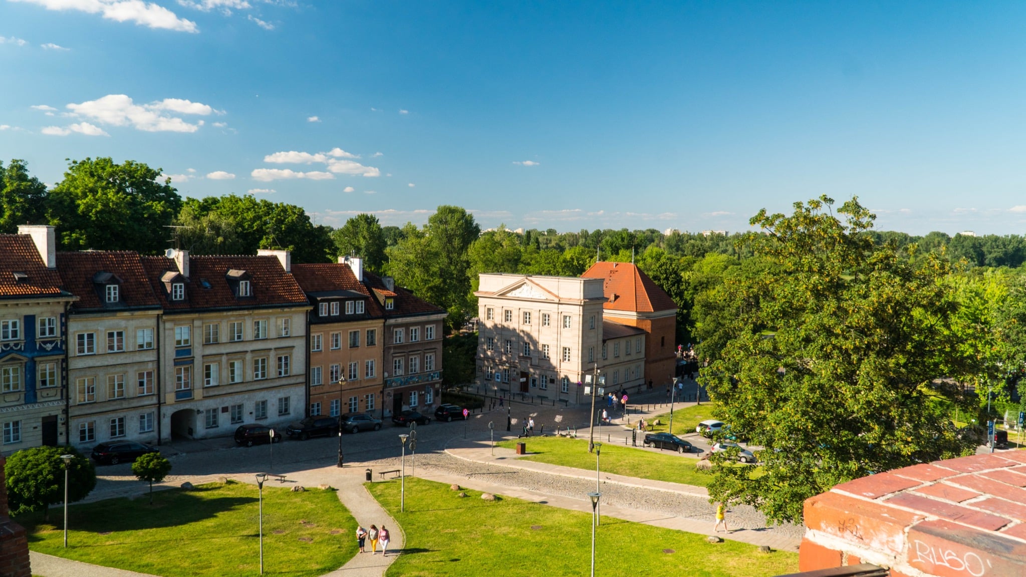 An elevated view over the New Town's tenement houses and greenery toward the Vistula