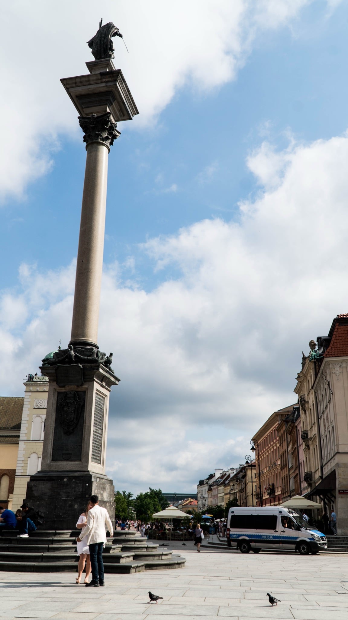 Sigismund's Column soaring over Castle Square as a couple stand at its base