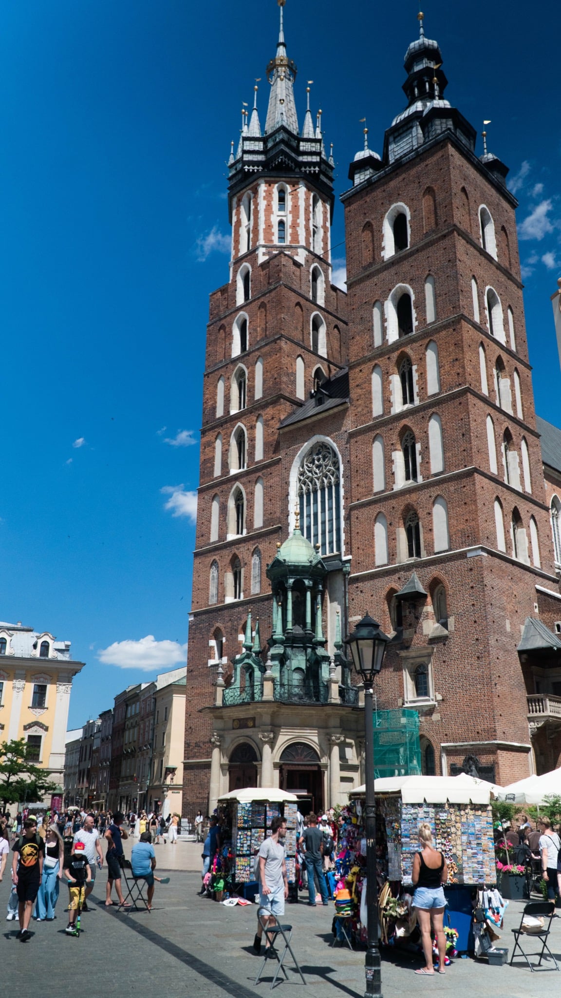 The mismatched twin towers of St. Mary's Basilica rising over the Main Square market stalls