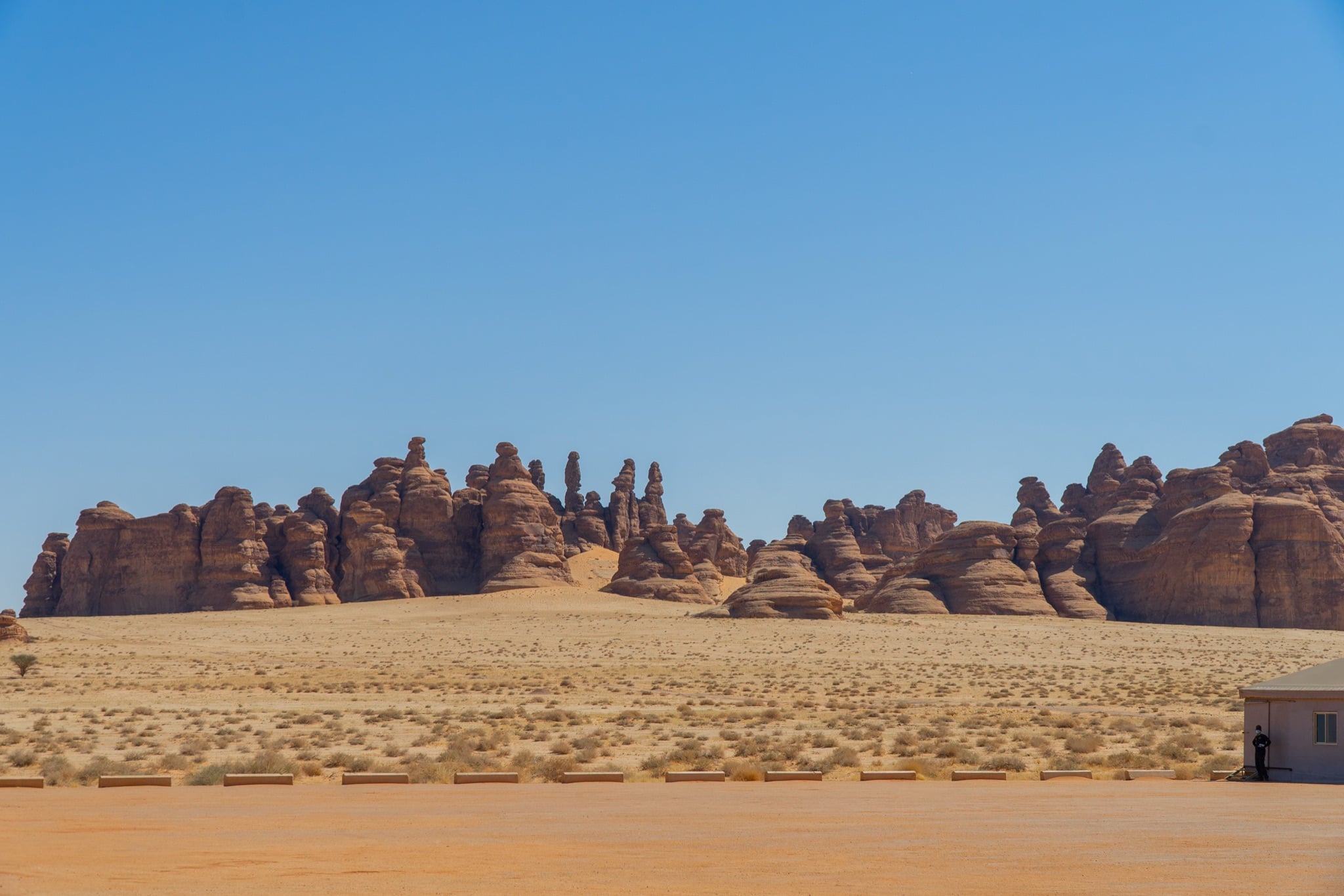 The desert plain ringed by Hegra's rock outcrops