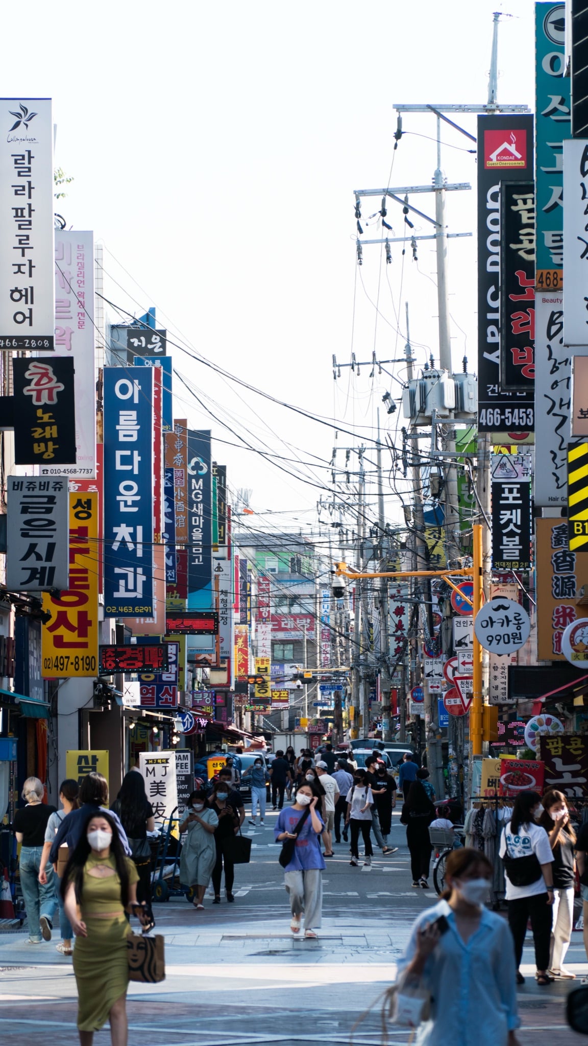 Signs and pedestrians along a Seoul street