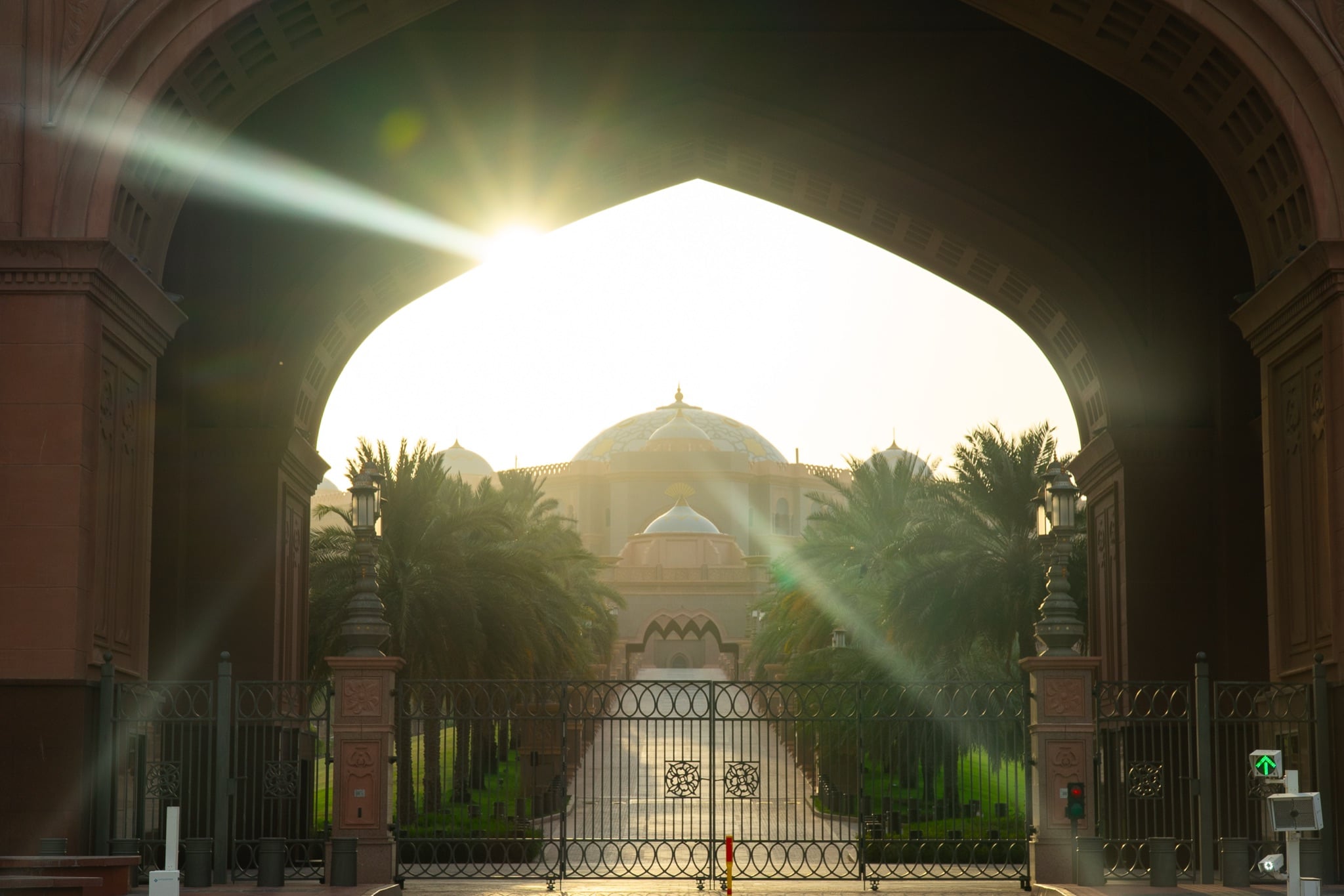 The domed Emirates Palace seen through its arched gateway at sunset