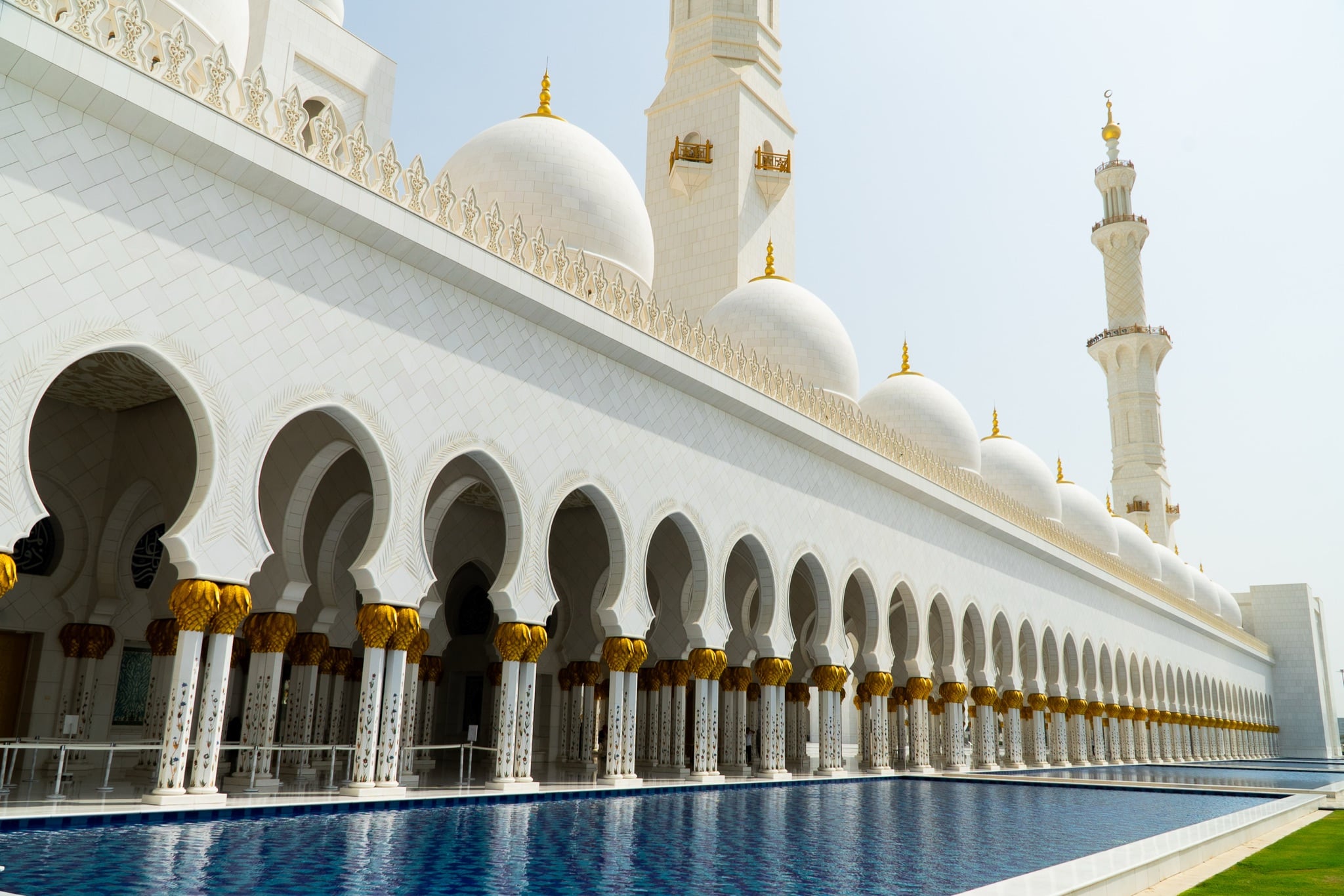 Rows of white domes along an arcaded wing of the mosque