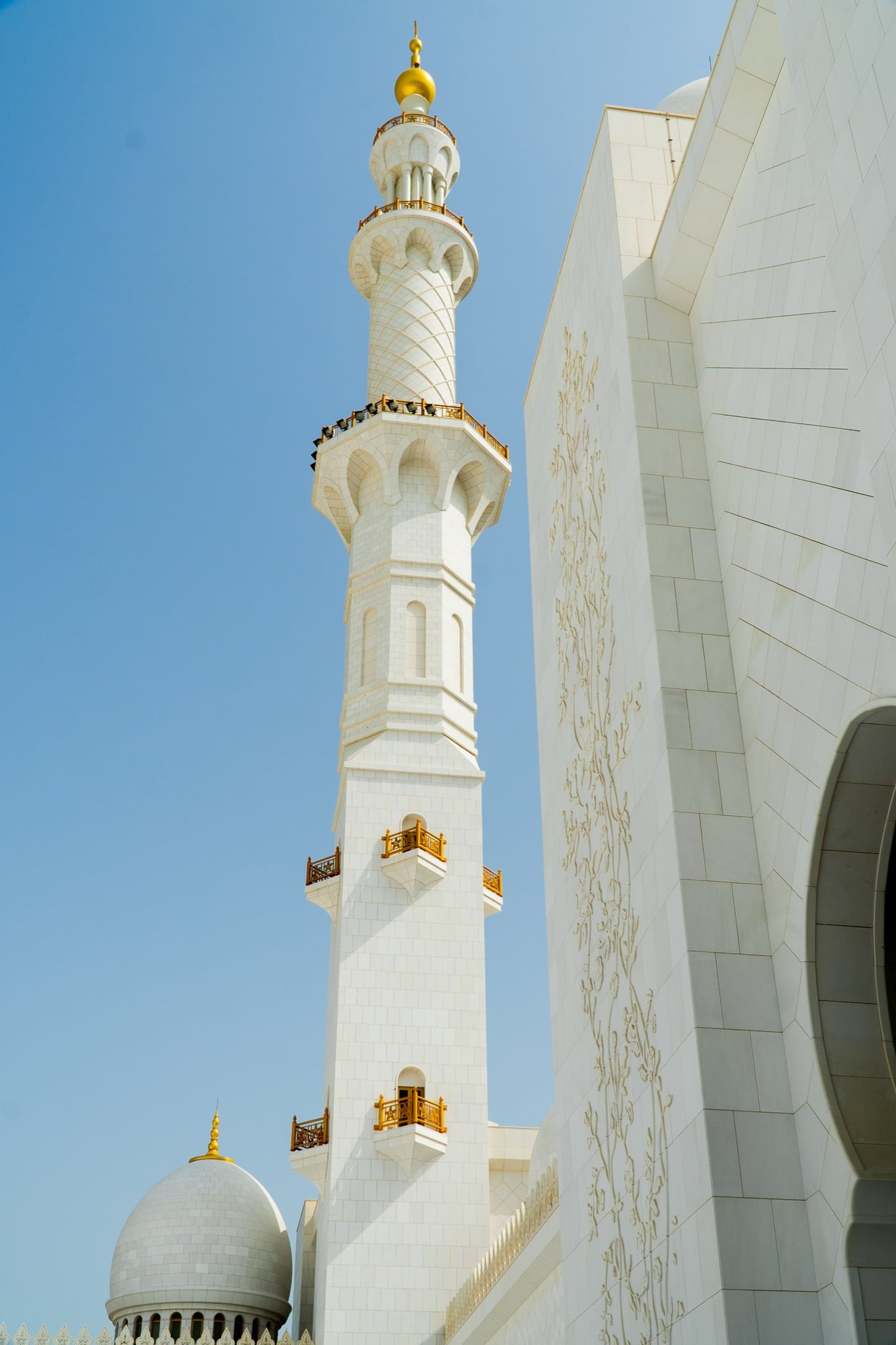 A slender minaret rising above the mosque's white colonnade