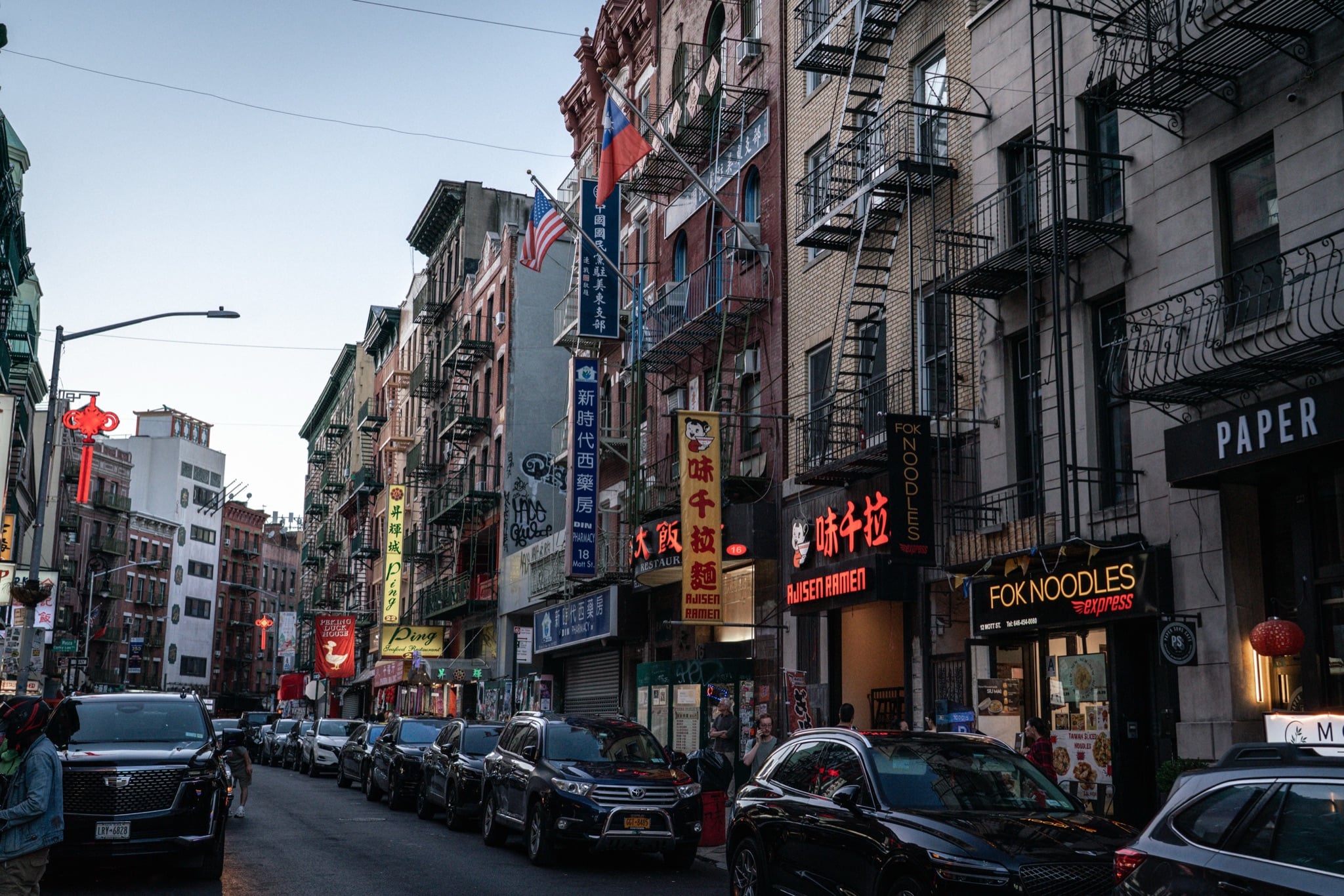 Signs and fire escapes along a Chinatown street