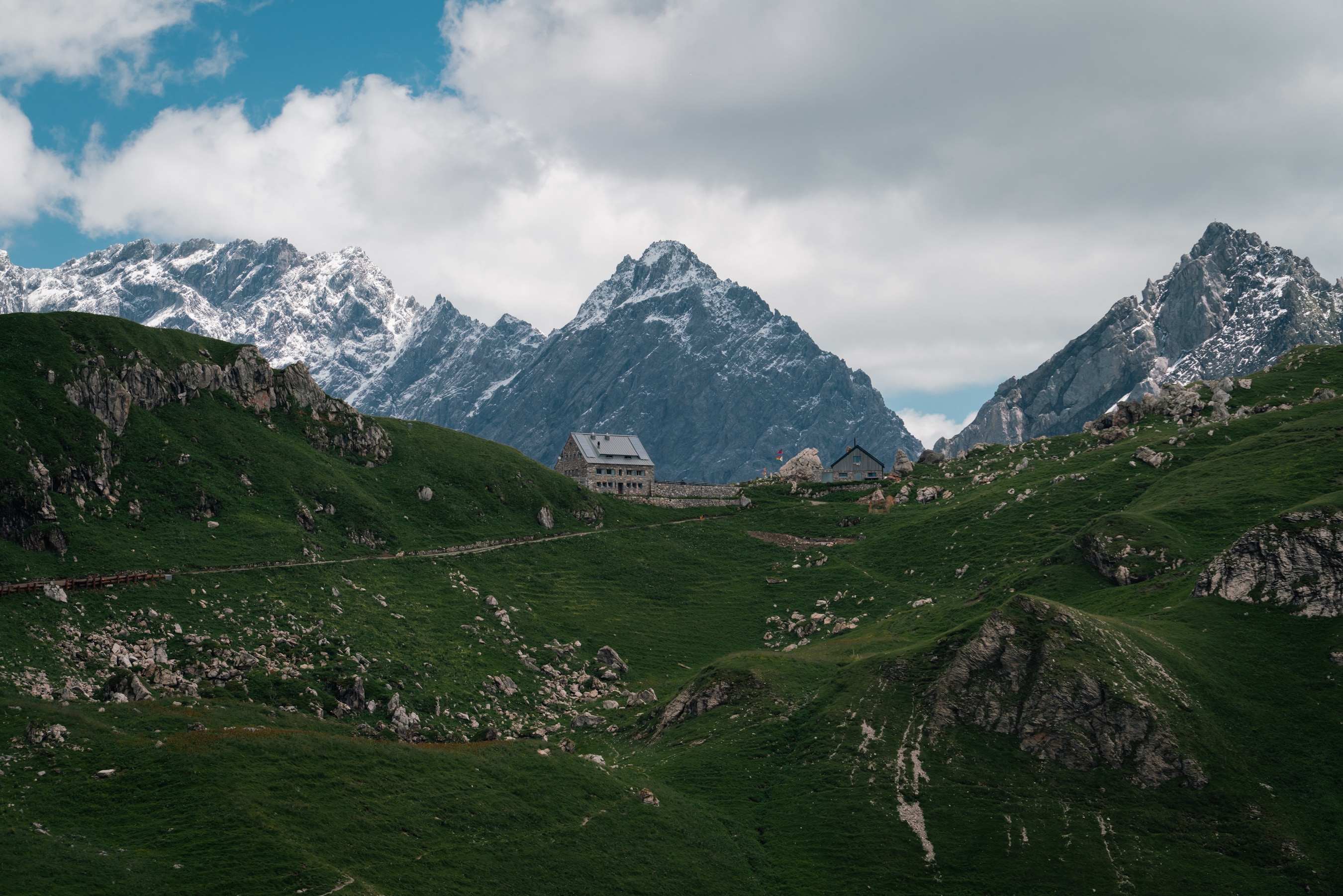Stone hut on a Liechtenstein ridge under moving cloud